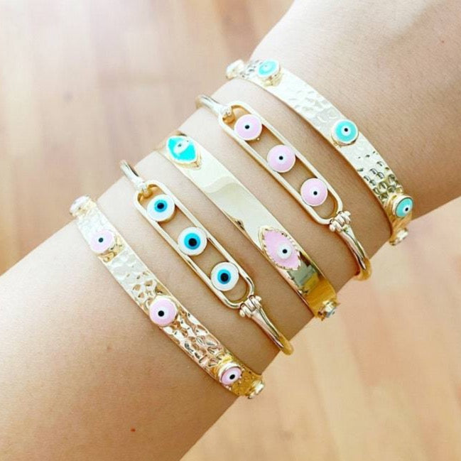 A beautiful gold cuff bracelet featuring a movable oval Evil Eye charm, perfect for Christmas gifts.