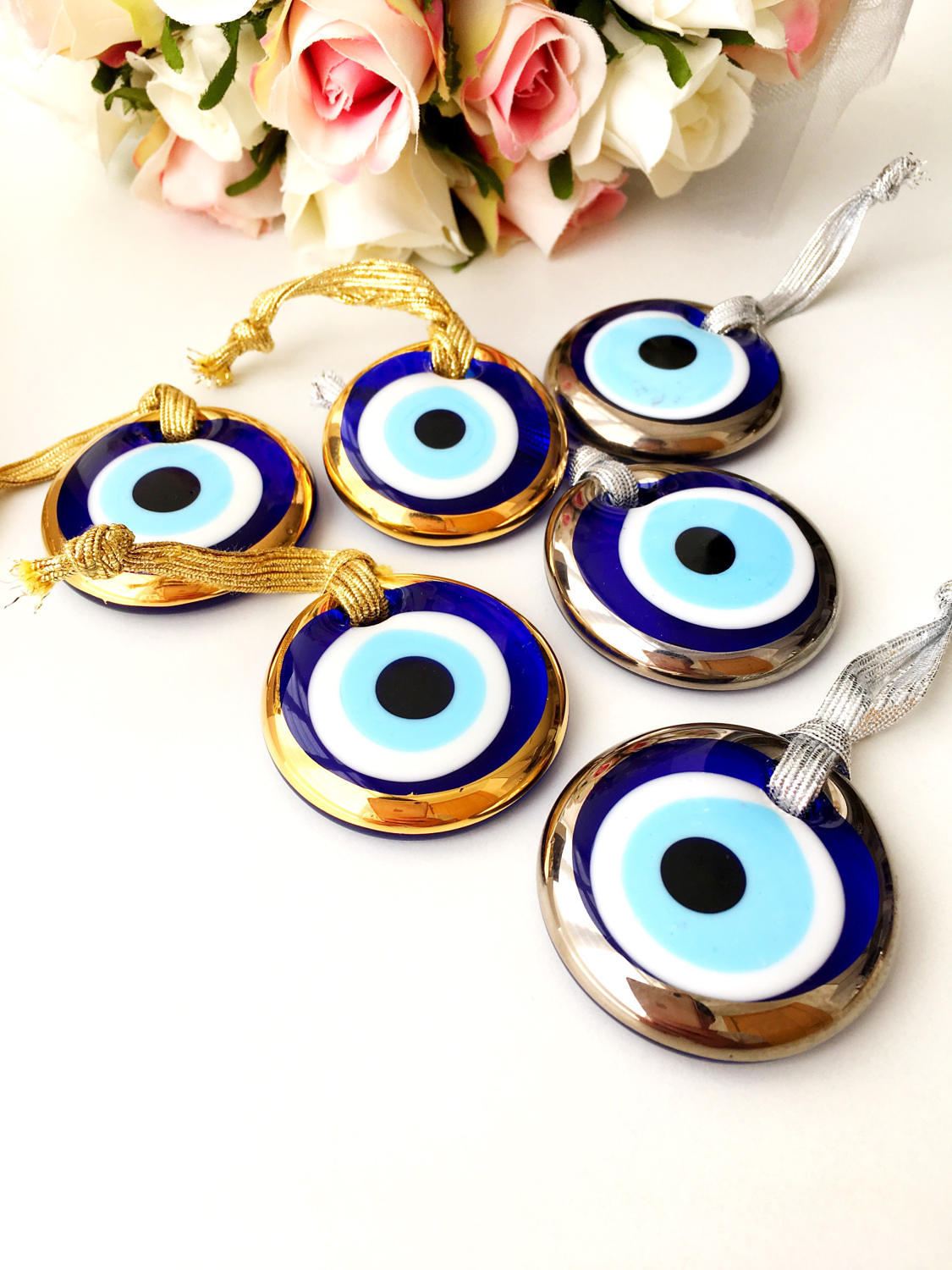 Three handmade evil eye beads in gold and silver rimmed designs, perfect for Christmas decoration and gifting.