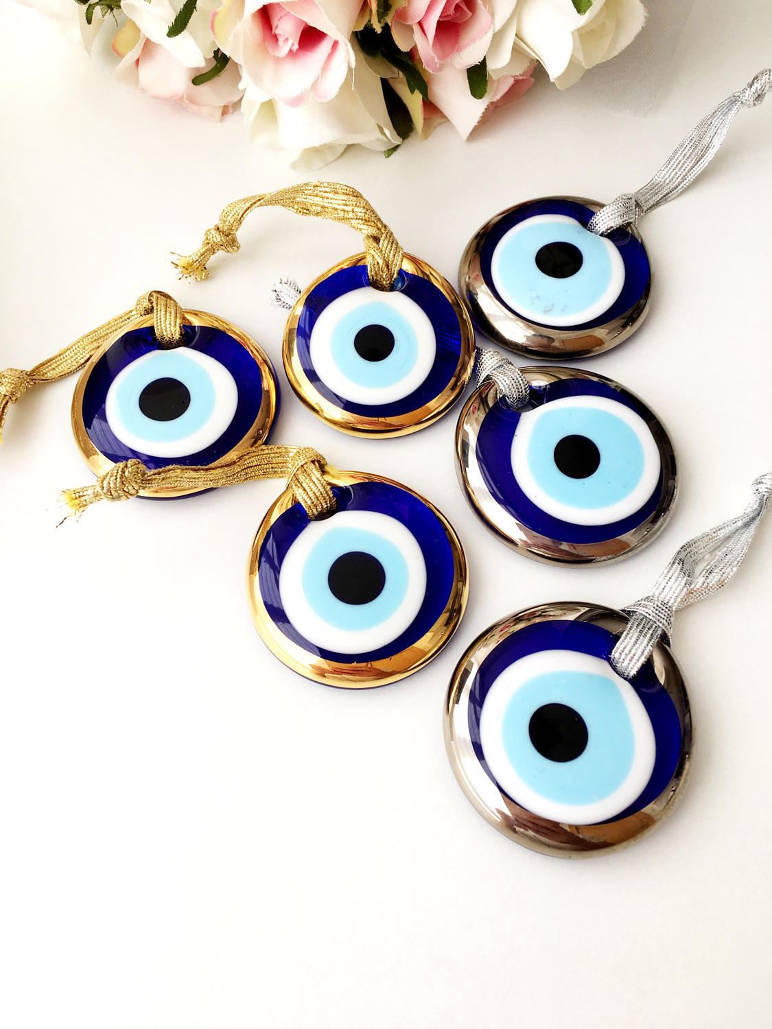 Three handmade evil eye beads in gold and silver rimmed designs, perfect for Christmas decoration and gifting.