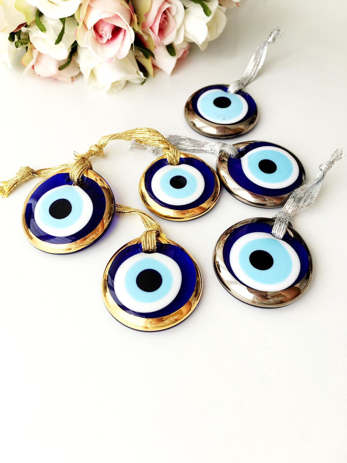 Three handmade evil eye beads in gold and silver rimmed designs, perfect for Christmas decoration and gifting.