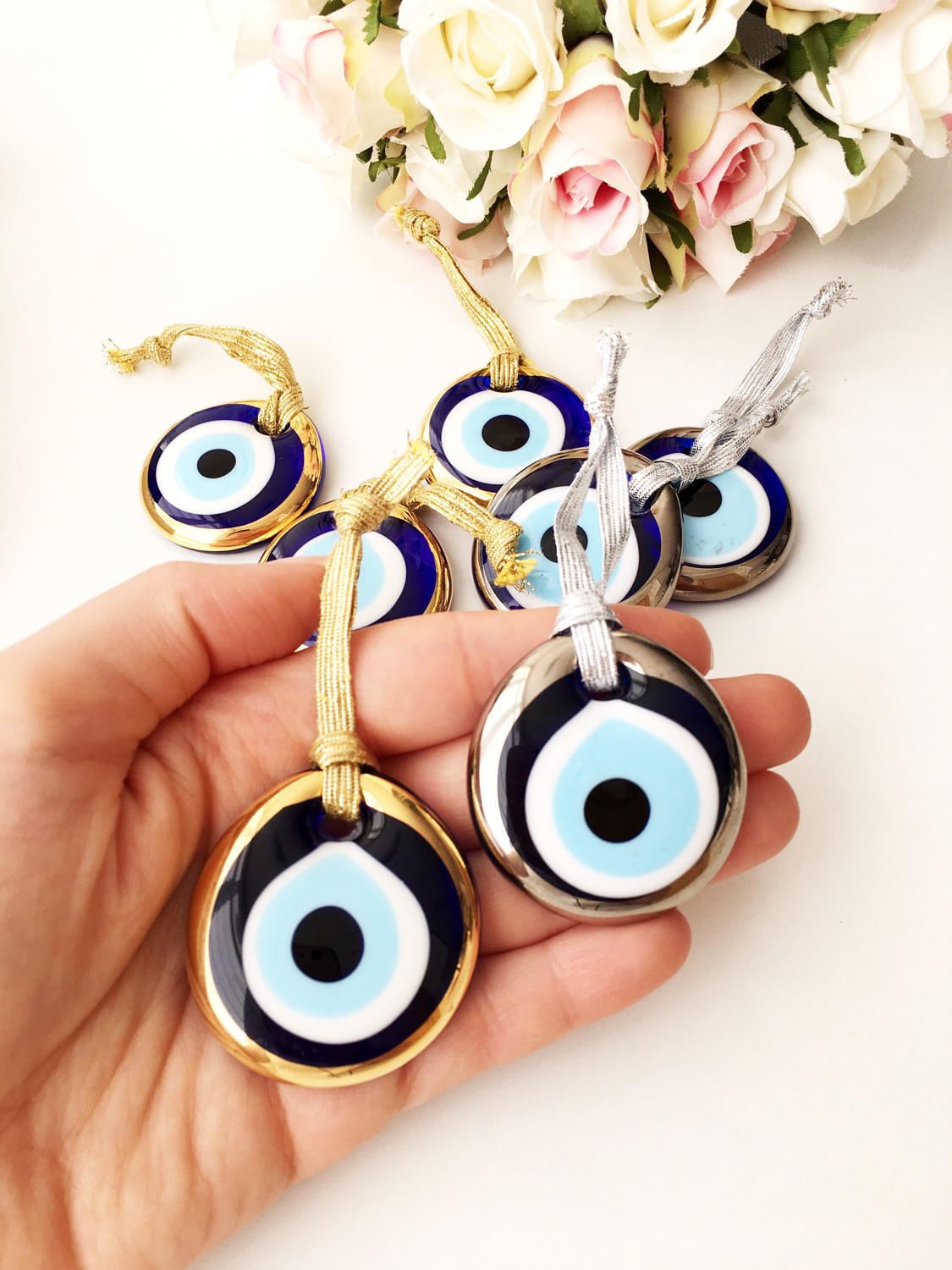 Three handmade evil eye beads in gold and silver rimmed designs, perfect for Christmas decoration and gifting.