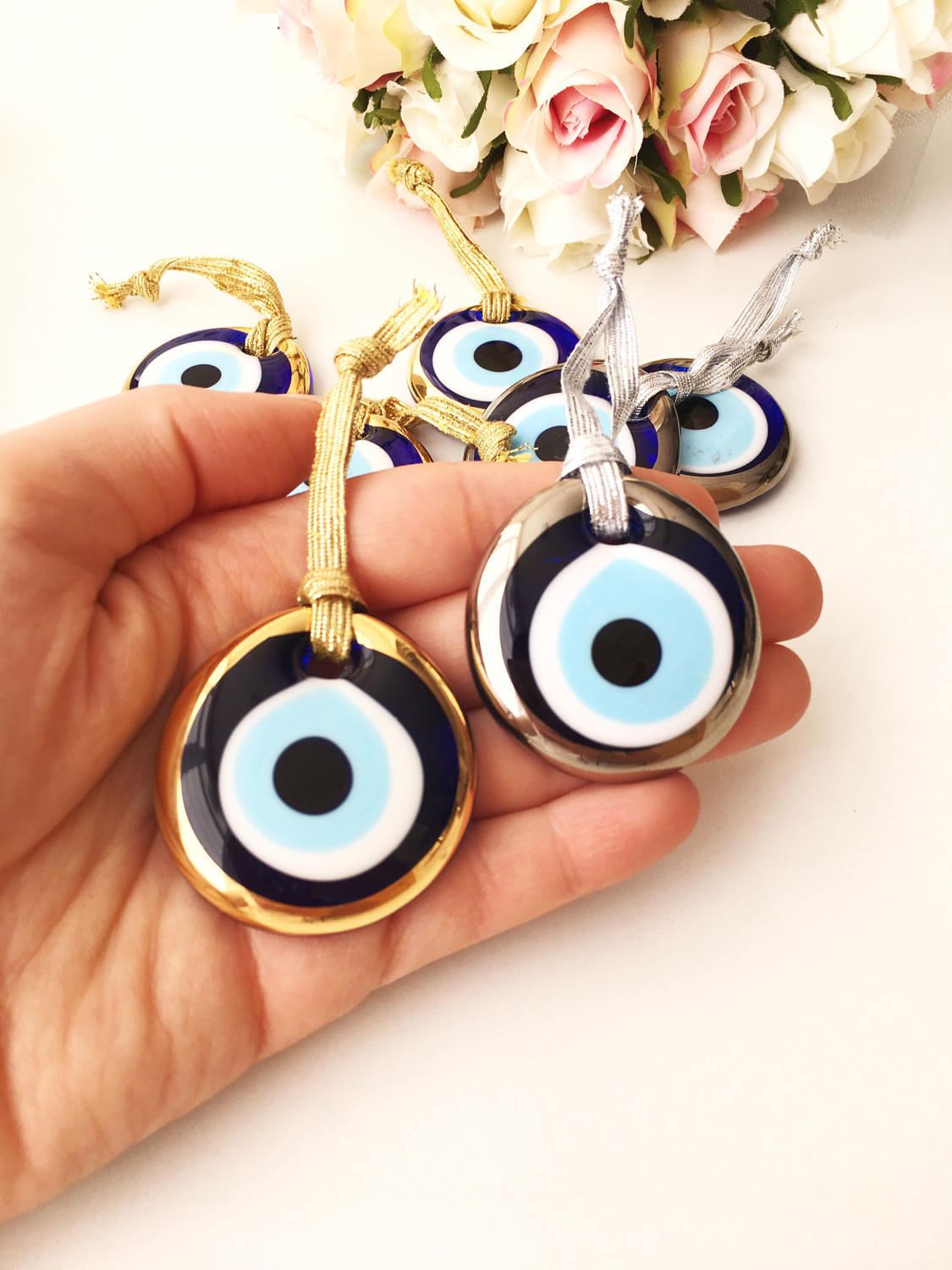 Three handmade evil eye beads in gold and silver rimmed designs, perfect for Christmas decoration and gifting.