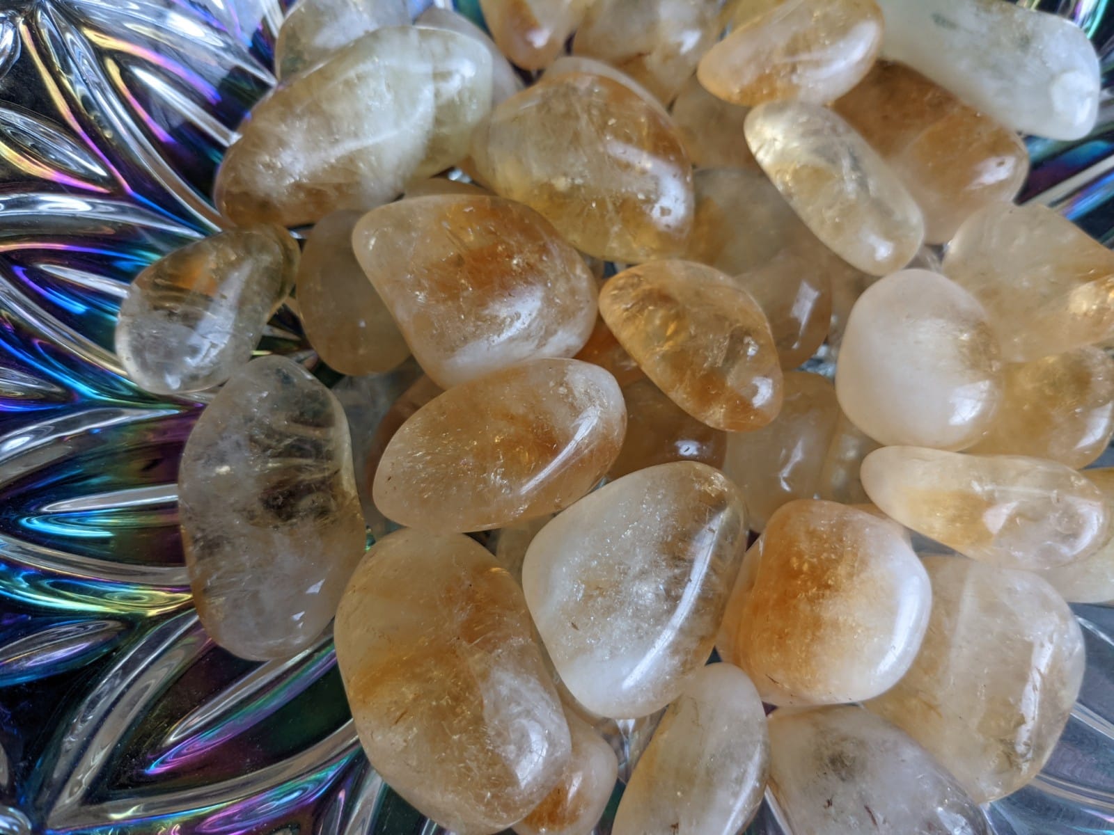 A collection of polished Citrine Tumble Stones showcasing their vibrant yellow color and unique textures, reflecting light beautifully.