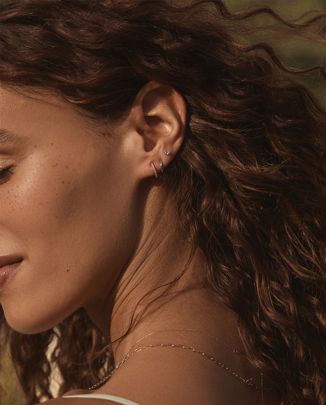 A pair of elegant gold stud earrings featuring round cut, bezel set diamonds, showcasing their brilliance and craftsmanship.