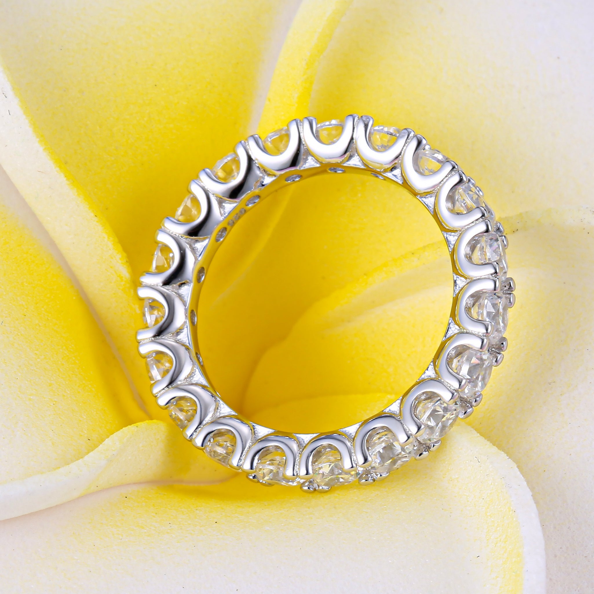 Classic Eternity Round Cut Women's Wedding Band made of sterling silver with white gold surface and white sapphires, showcasing elegance and durability.