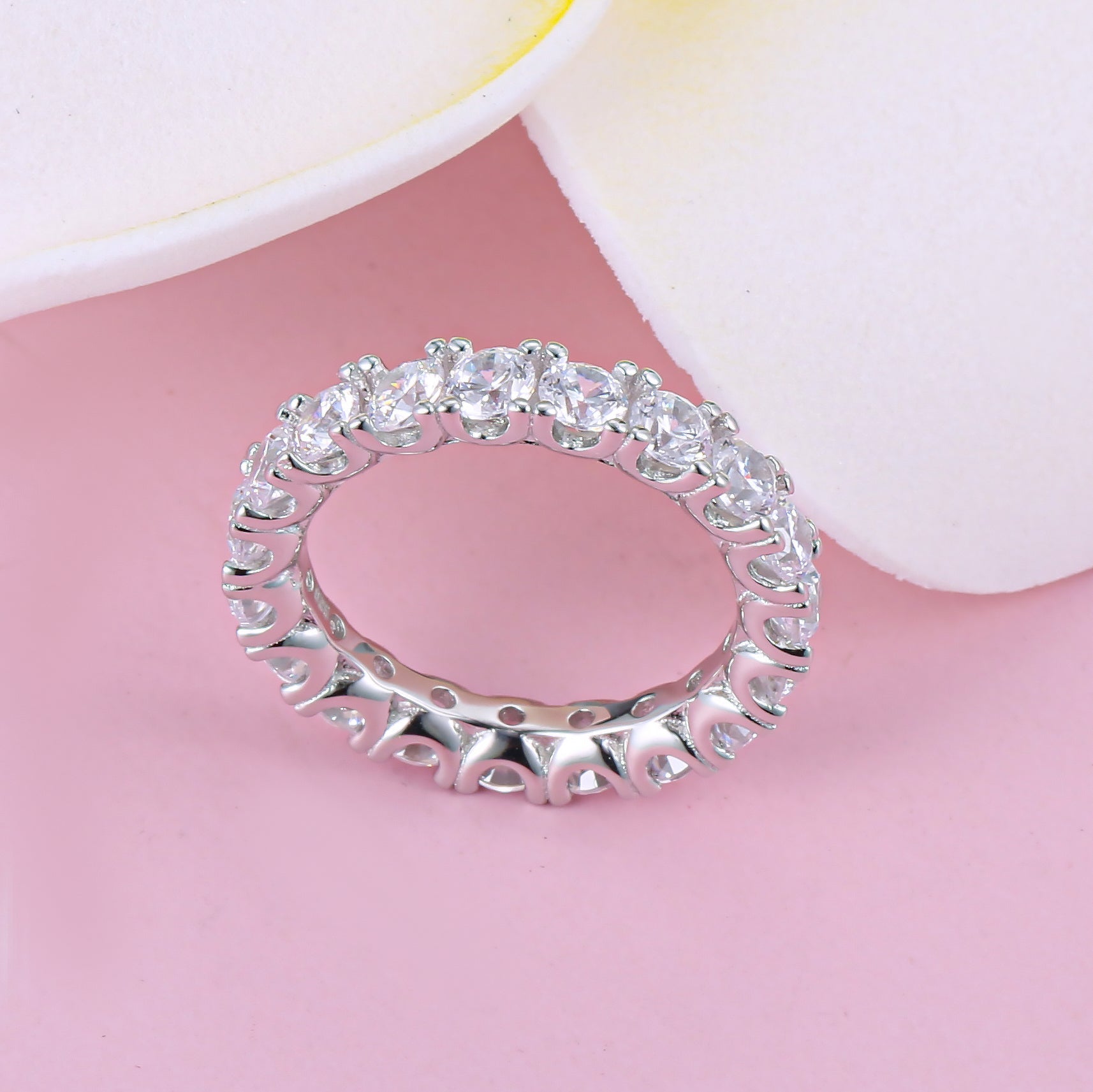 Classic Eternity Round Cut Women's Wedding Band made of sterling silver with white gold surface and white sapphires, showcasing elegance and durability.