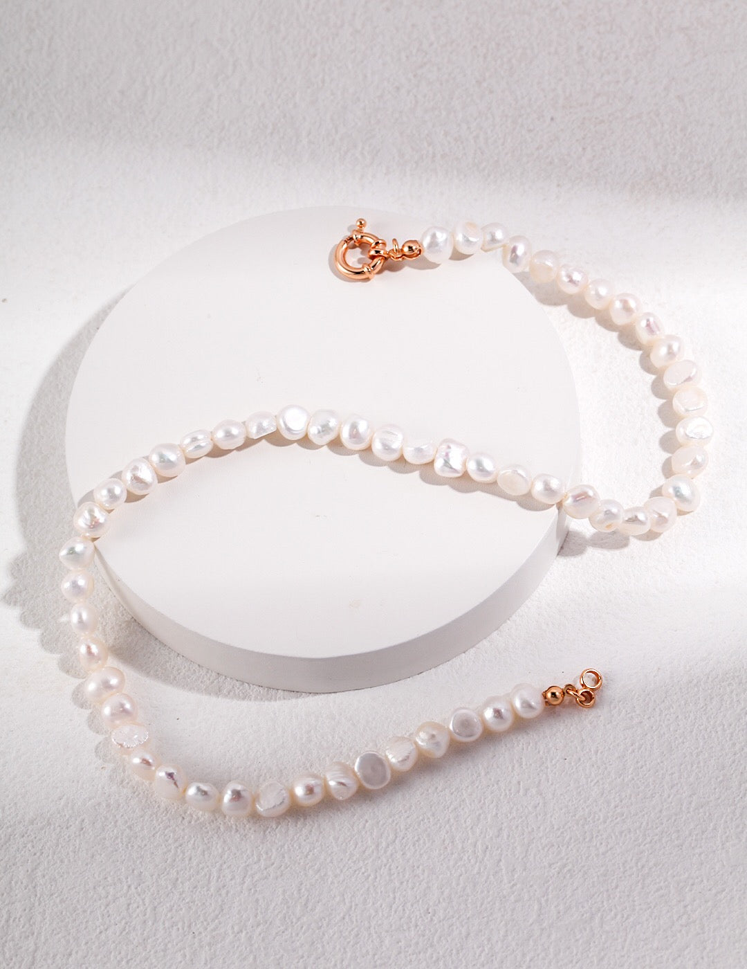 Classic Freshwater Nugget Pearl Necklace featuring natural pearls and gold vermeil, elegantly displayed in a jewelry pouch.