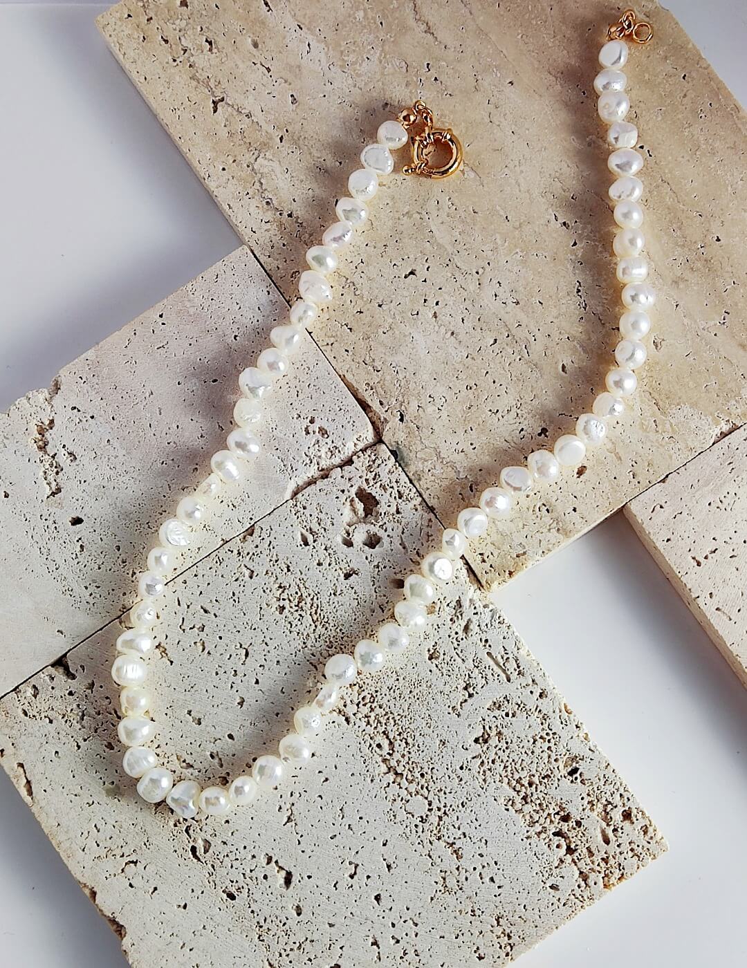 Classic Freshwater Nugget Pearl Necklace featuring natural pearls and gold vermeil, elegantly displayed in a jewelry pouch.