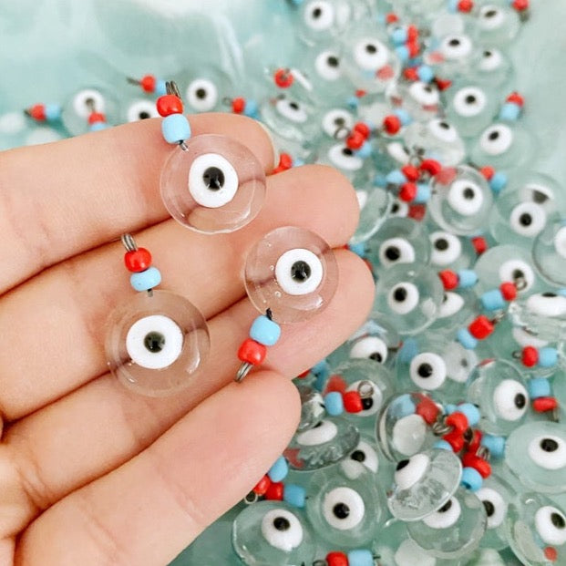 A collection of Clear Evil Eye Beads made from Murano glass, showcasing their vibrant colors and intricate designs, perfect for jewelry making.