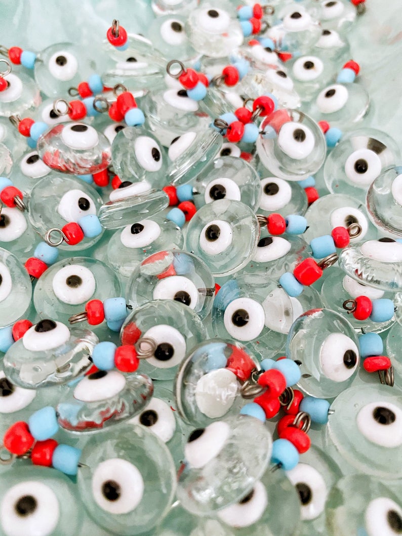 A collection of Clear Evil Eye Beads made from Murano glass, showcasing their vibrant colors and intricate designs, perfect for jewelry making.