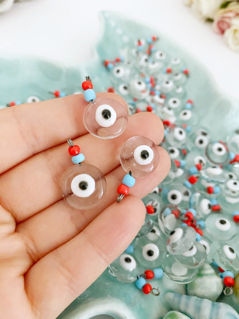 A collection of Clear Evil Eye Beads made from Murano glass, showcasing their vibrant colors and intricate designs, perfect for jewelry making.
