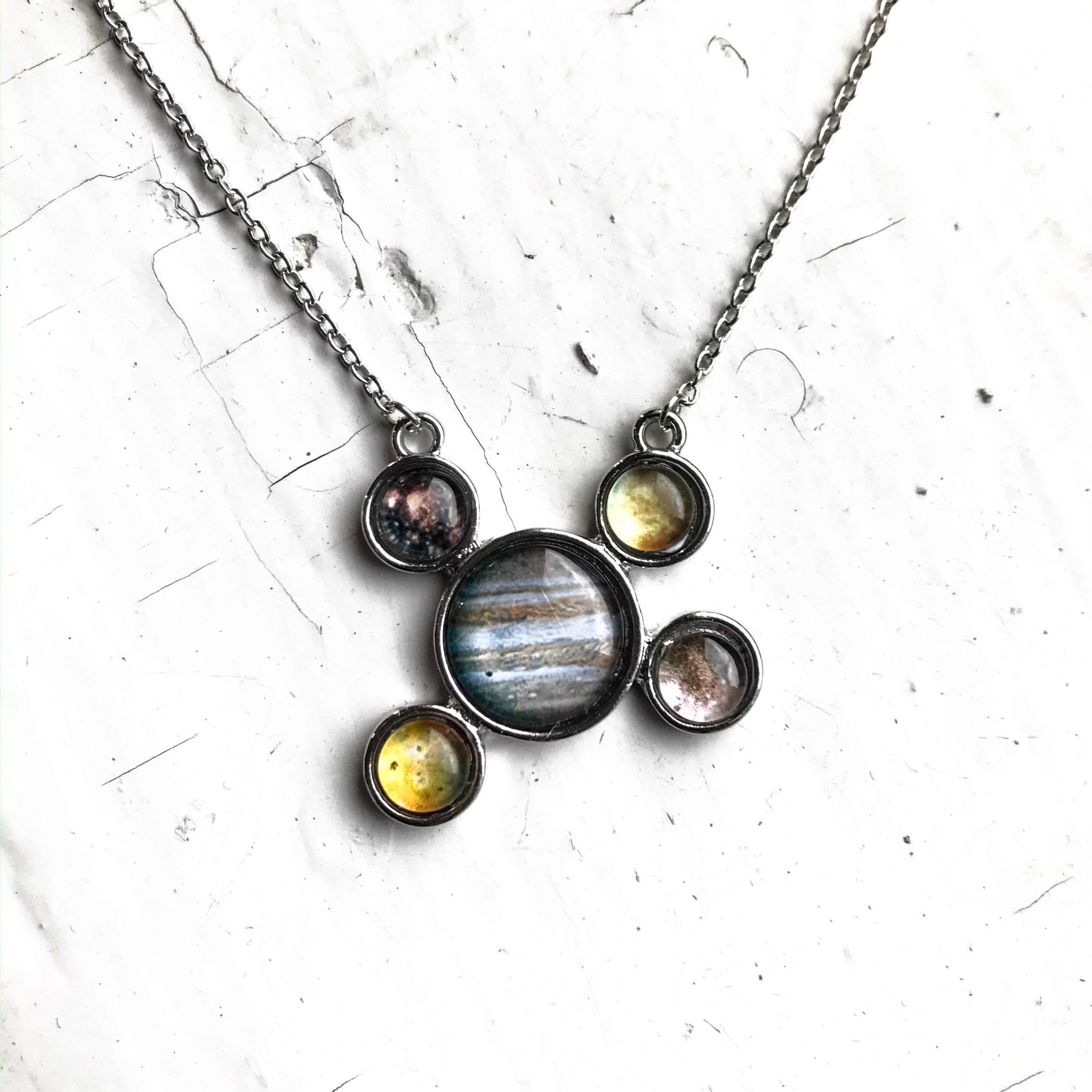 Handcrafted silver pendant necklace featuring Jupiter and its Galilean Moons, showcasing intricate details and a rhodium plated finish.
