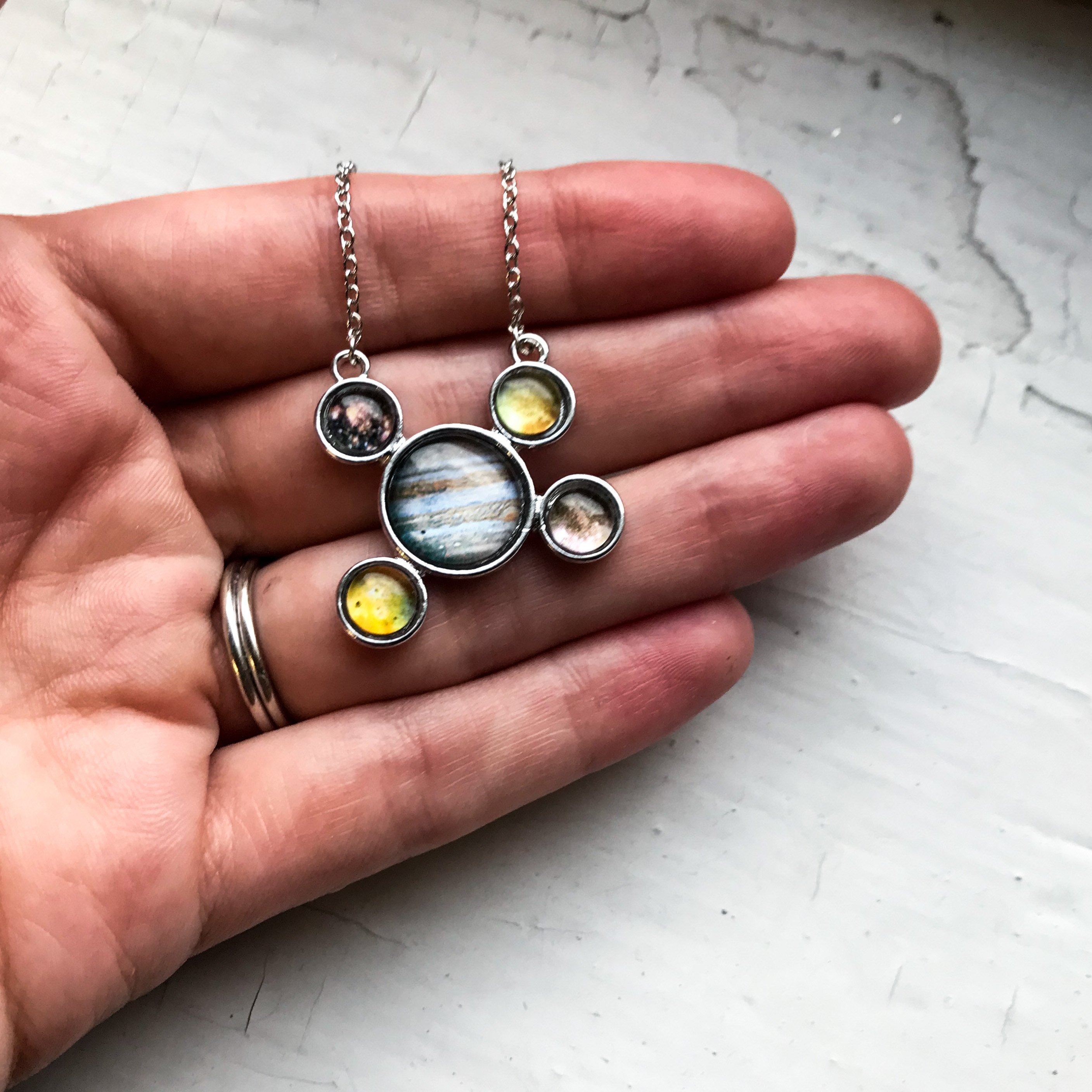 Handcrafted silver pendant necklace featuring Jupiter and its Galilean Moons, showcasing intricate details and a rhodium plated finish.