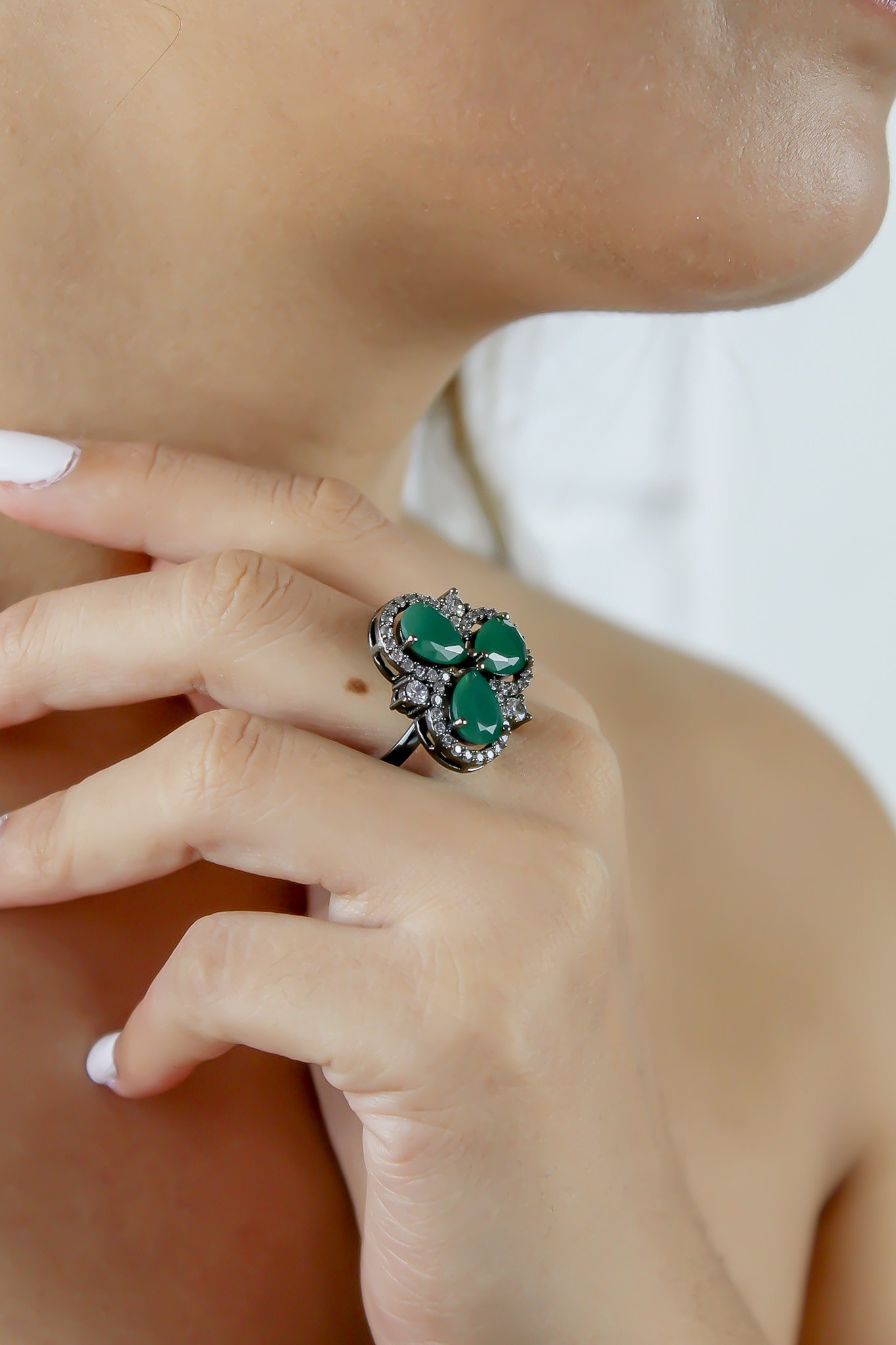 Cloverfield Ring featuring colorful sparkling zircons and adjustable design, elegantly displayed on a soft surface.
