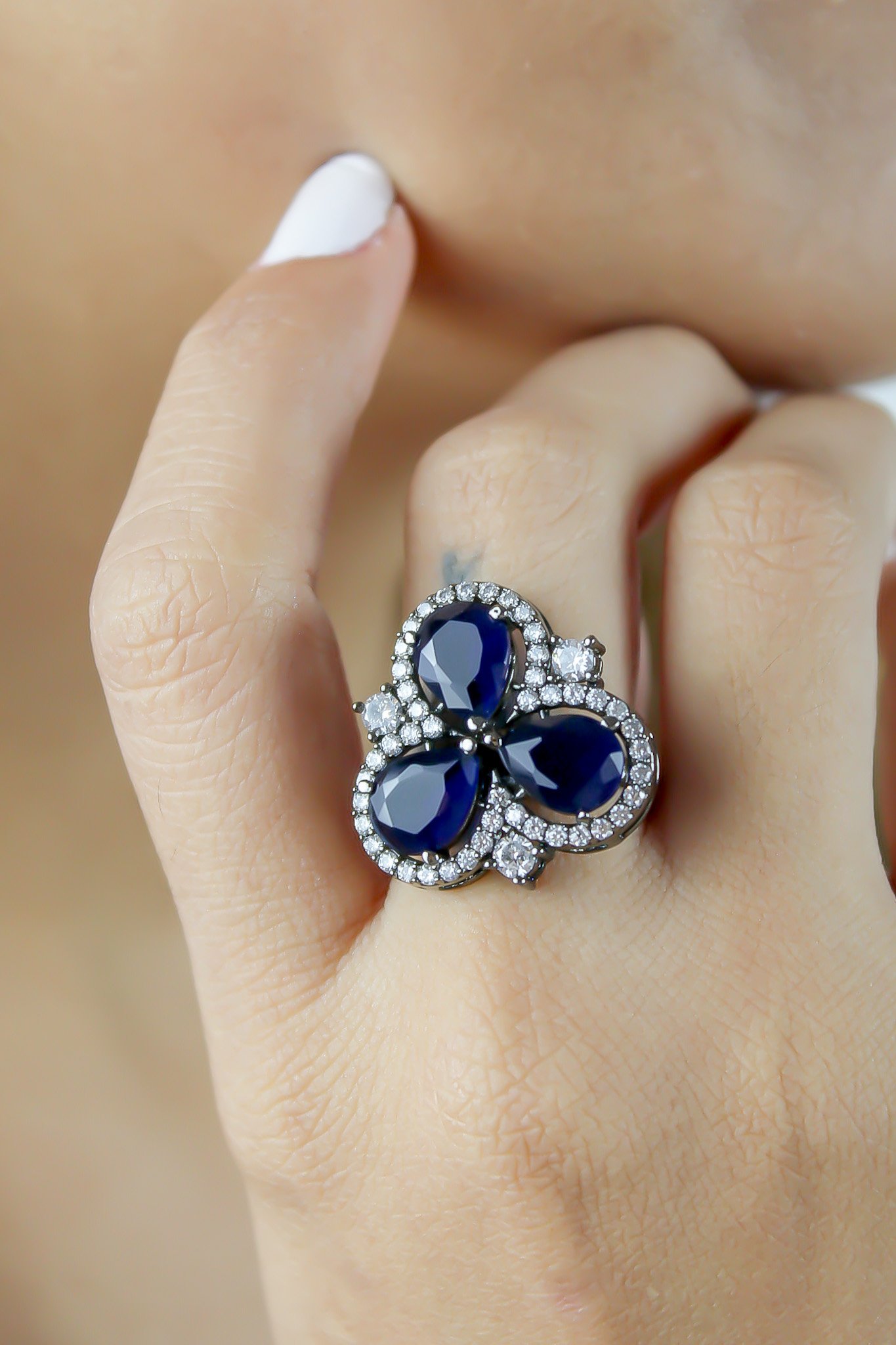 Cloverfield Ring featuring colorful sparkling zircons and adjustable design, elegantly displayed on a soft surface.