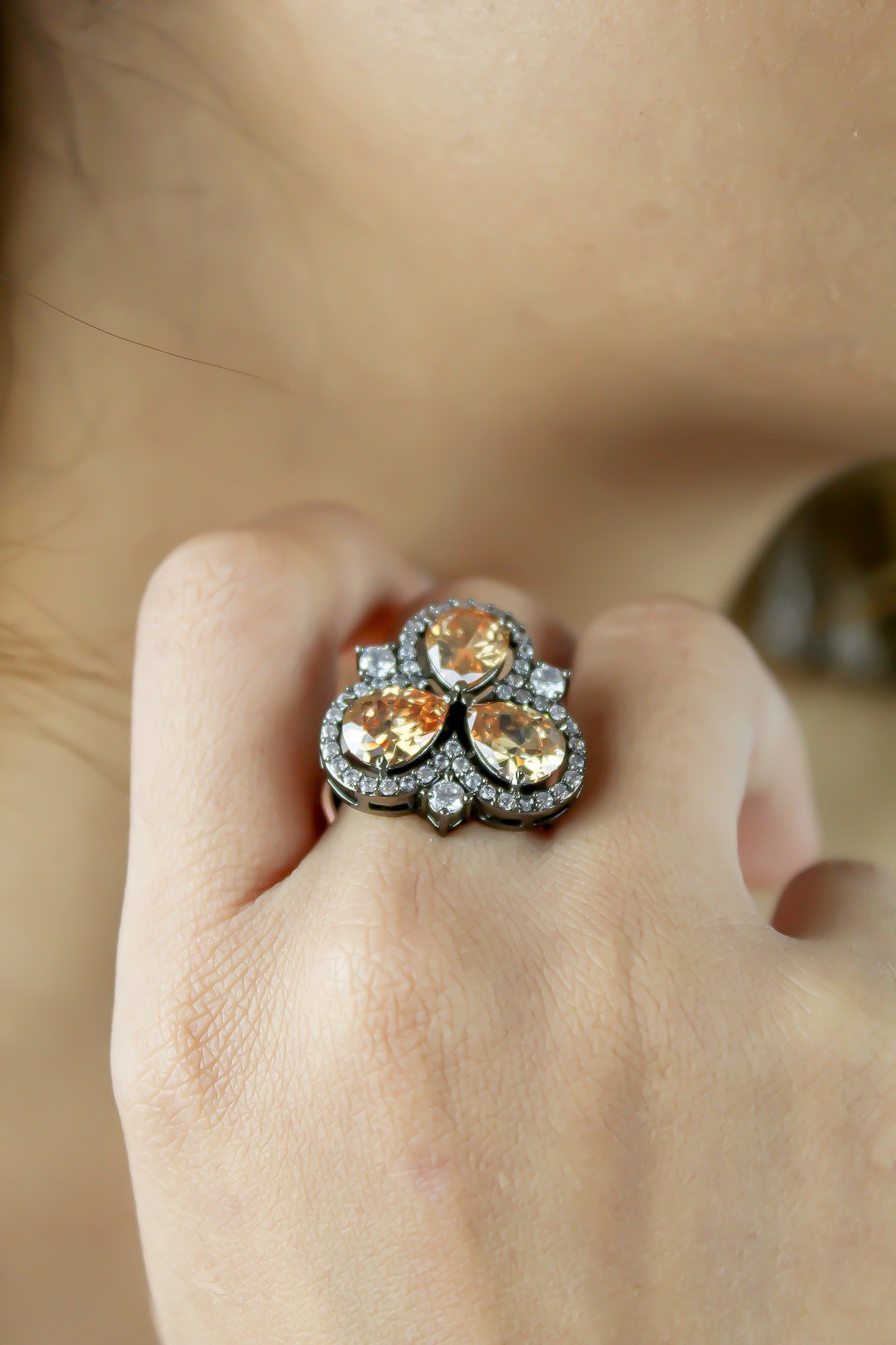 Cloverfield Ring featuring colorful sparkling zircons and adjustable design, elegantly displayed on a soft surface.