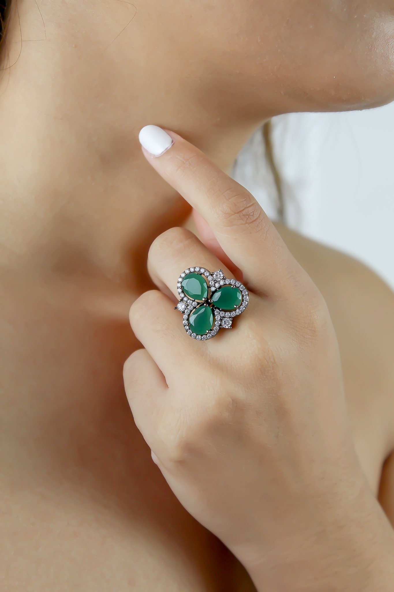 Cloverfield Ring featuring colorful sparkling zircons and adjustable design, elegantly displayed on a soft surface.