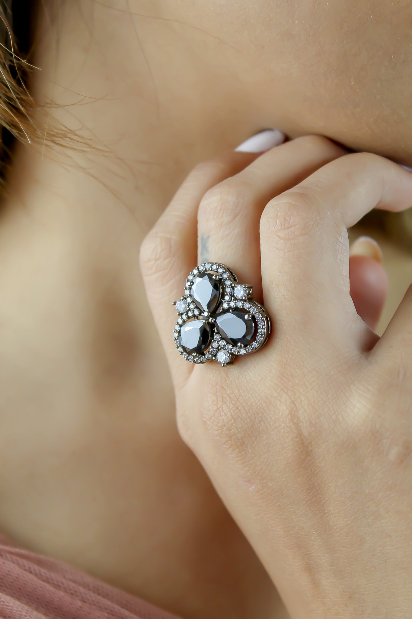 Cloverfield Ring featuring colorful sparkling zircons and adjustable design, elegantly displayed on a soft surface.
