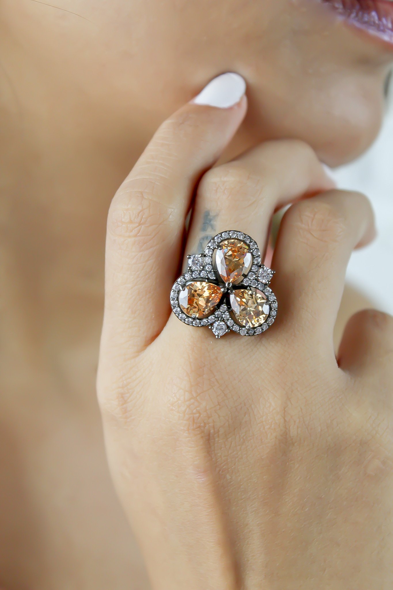 Cloverfield Ring featuring colorful sparkling zircons and adjustable design, elegantly displayed on a soft surface.