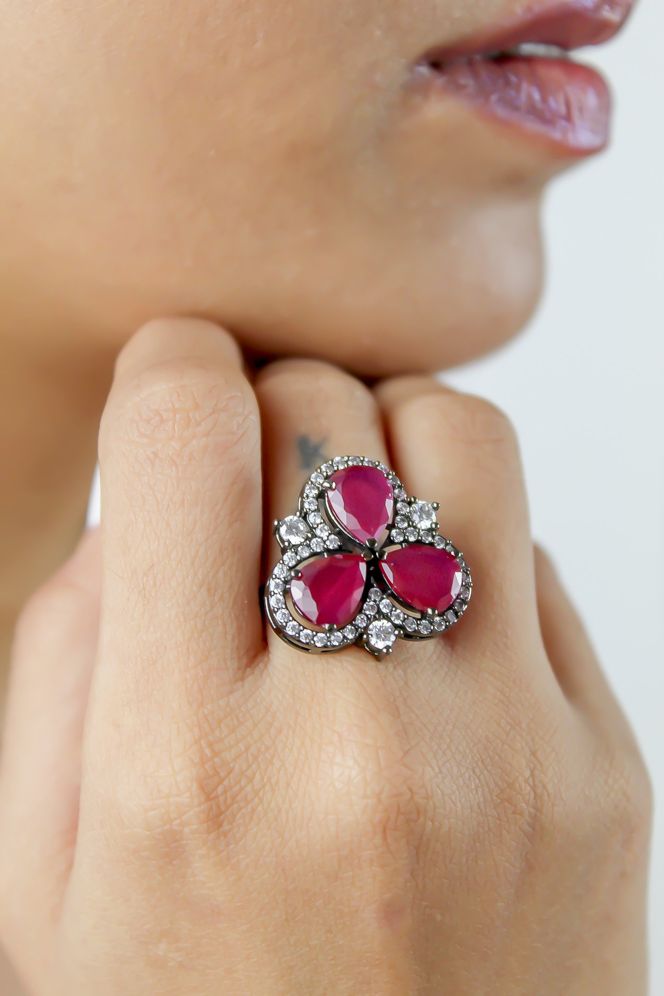 Cloverfield Ring featuring colorful sparkling zircons and adjustable design, elegantly displayed on a soft surface.
