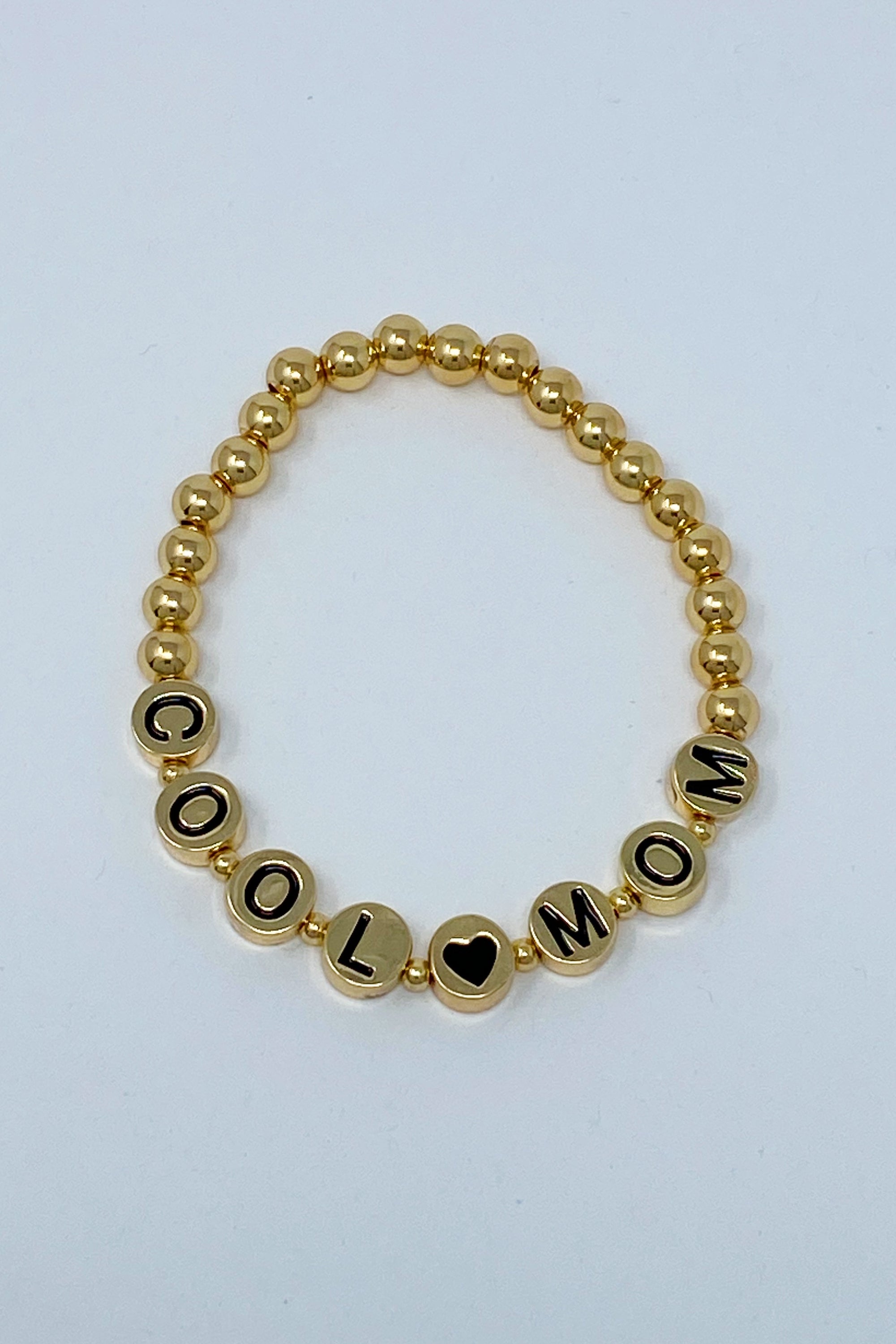 Cool Mom Gold Bead Bracelet featuring gold tone ball beads and black letter beads, showcasing a stylish and personalized design.