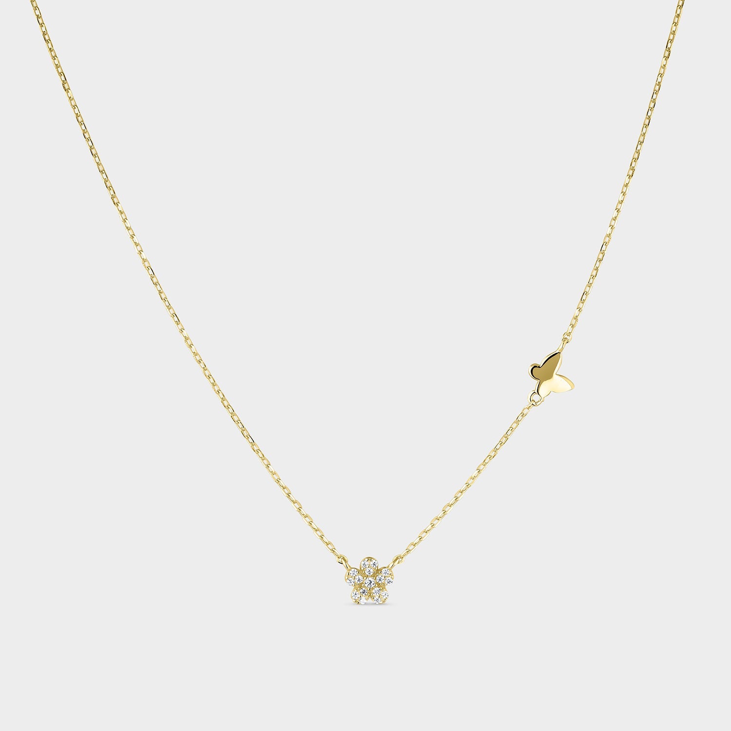 Collar de plata bañada en oro amarillo con diseño de mariposa y flor, adornado con circonitas blancas brillantes.