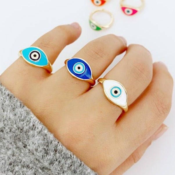 Colorful Evil Eye Ring featuring a gold band and an oval evil eye bead in blue, white, and turquoise colors, adjustable for all sizes.