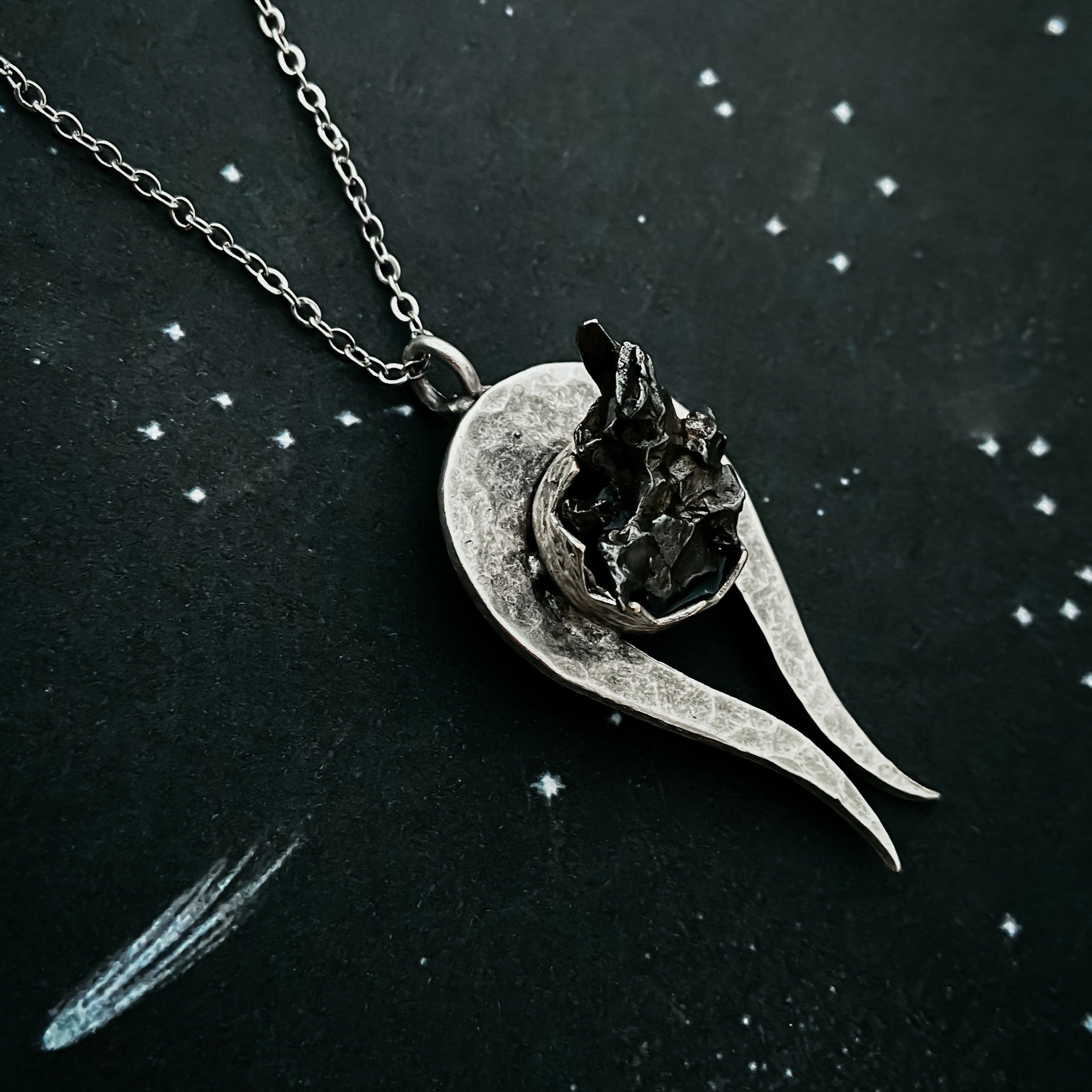 Comet Necklace featuring a chunk of authentic Campo del Cielo meteorite on a hammered silver pendant with a leather or metal chain.
