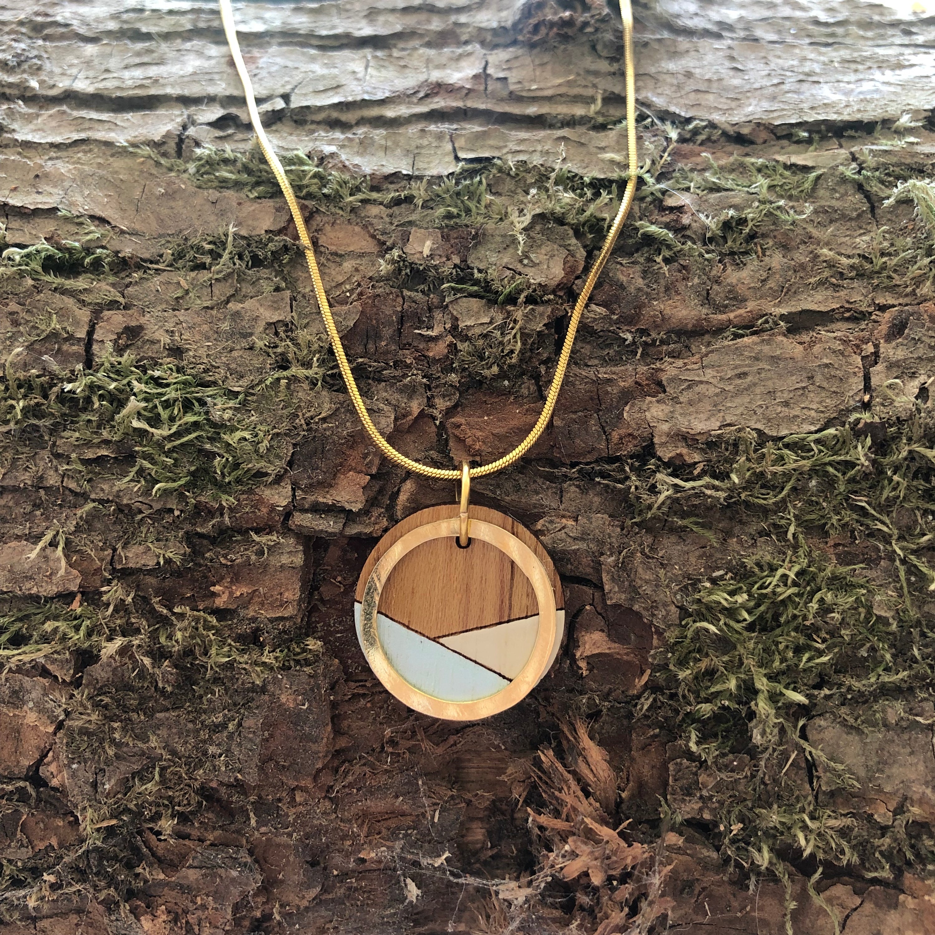 Conture Recycled Wood Gold Chain Necklace featuring a unique wooden pendant and gold plated chain, available in four nature-inspired colors.