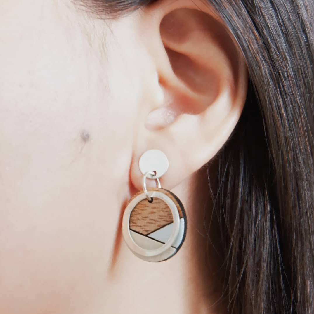 Conture Recycled Wood Silver Earrings showcasing unique wood patterns and sterling silver backing, available in six colors.