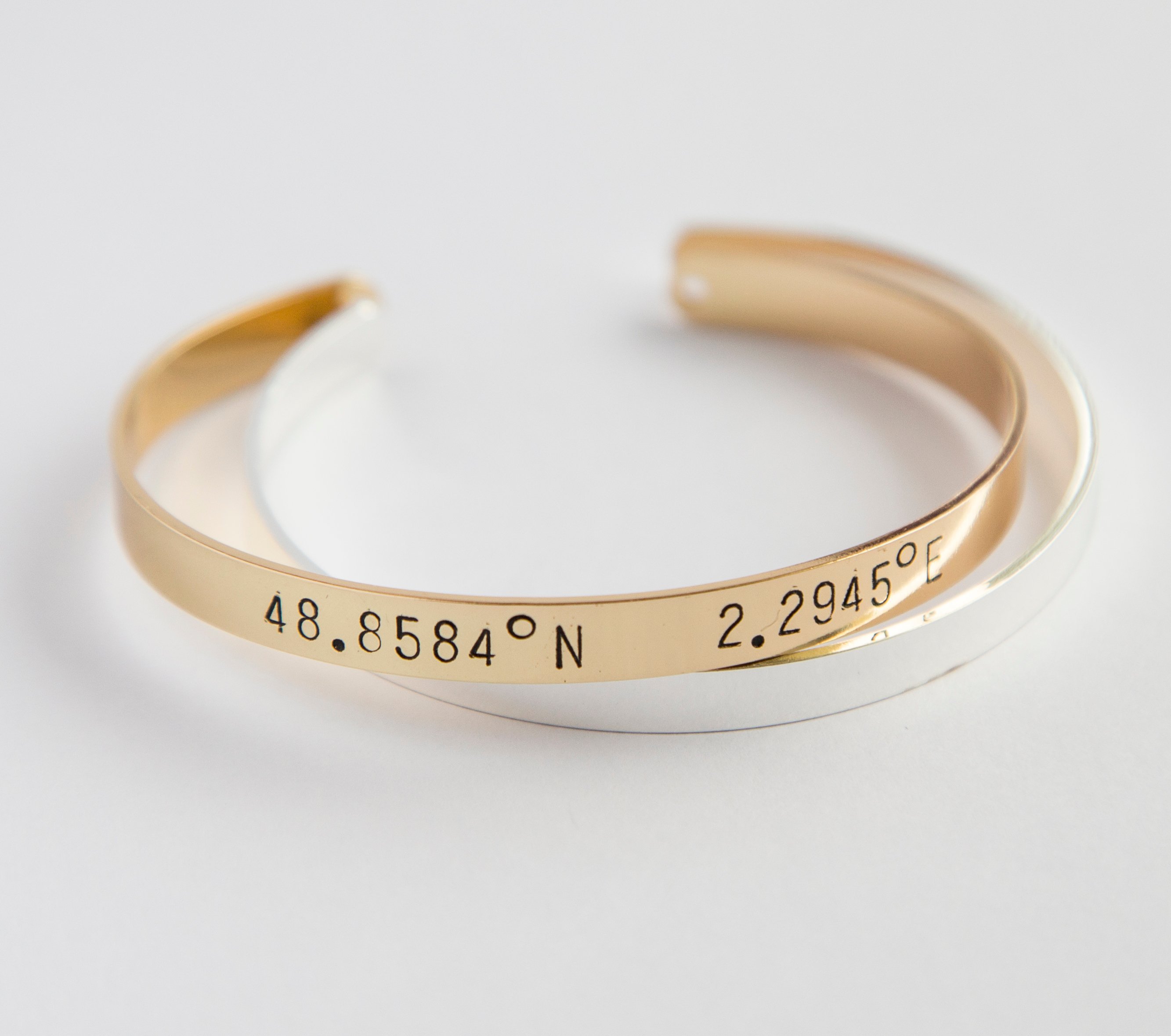 A beautiful adjustable Coordinates bracelet in gold and silver plating, showcasing a unique hand-stamped design.
