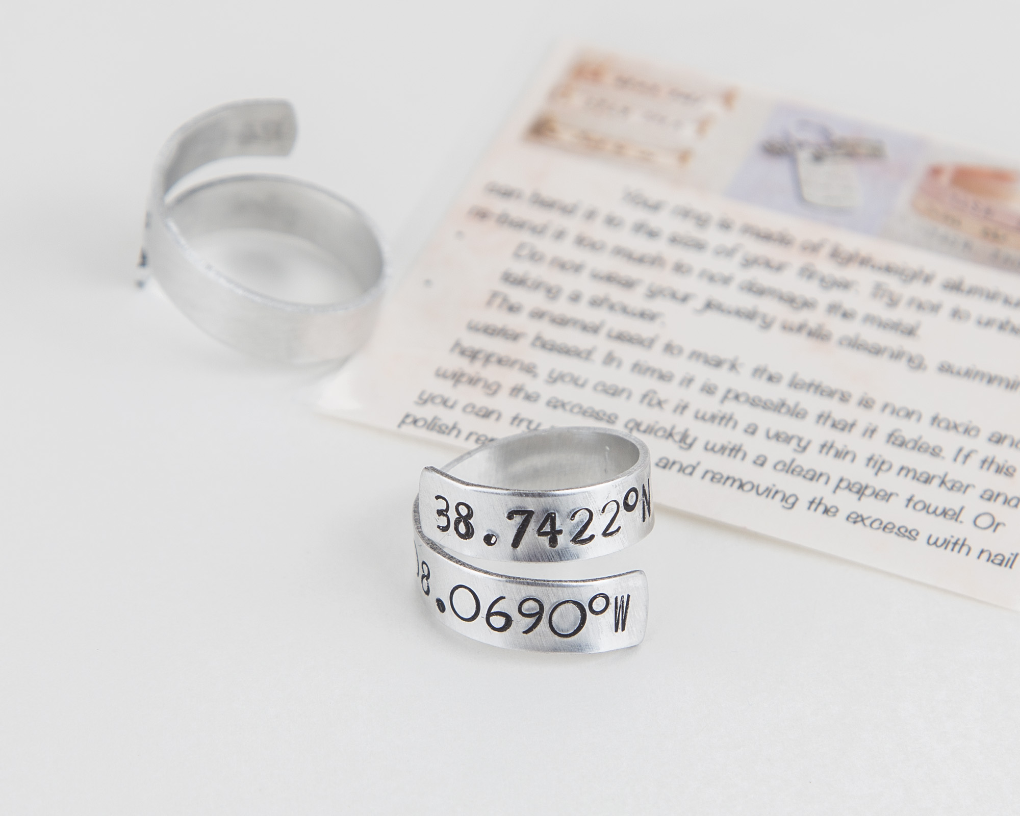 Adjustable aluminum coordinates ring, hand-stamped with personalized location details, perfect for long-distance relationships.