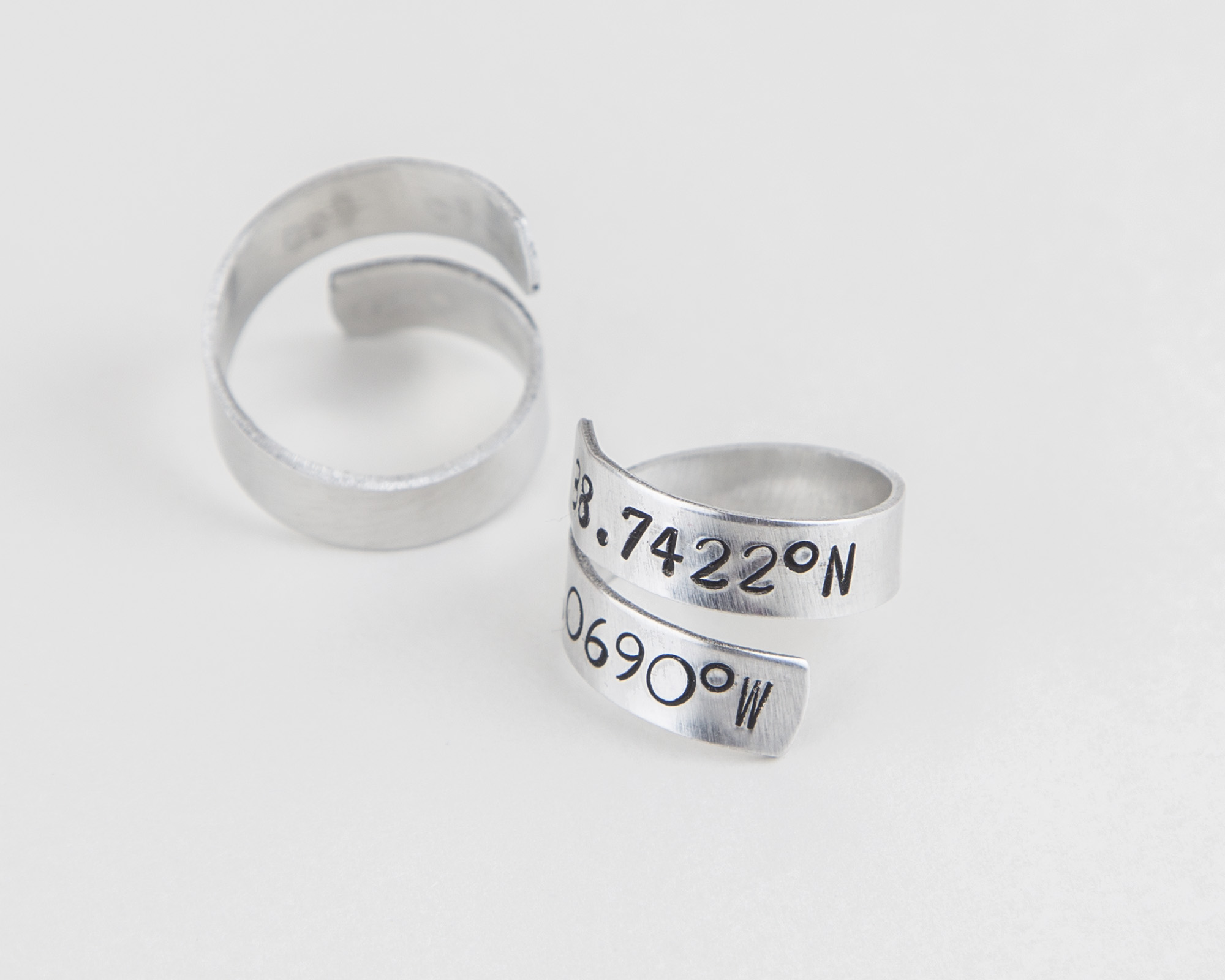 Adjustable aluminum coordinates ring, hand-stamped with personalized location details, perfect for long-distance relationships.