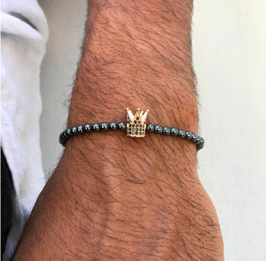 Coronet Steel Bracelet CZ featuring a copper-colored metallic bead and a stunning crown pendant, elegantly designed for a luxurious look.