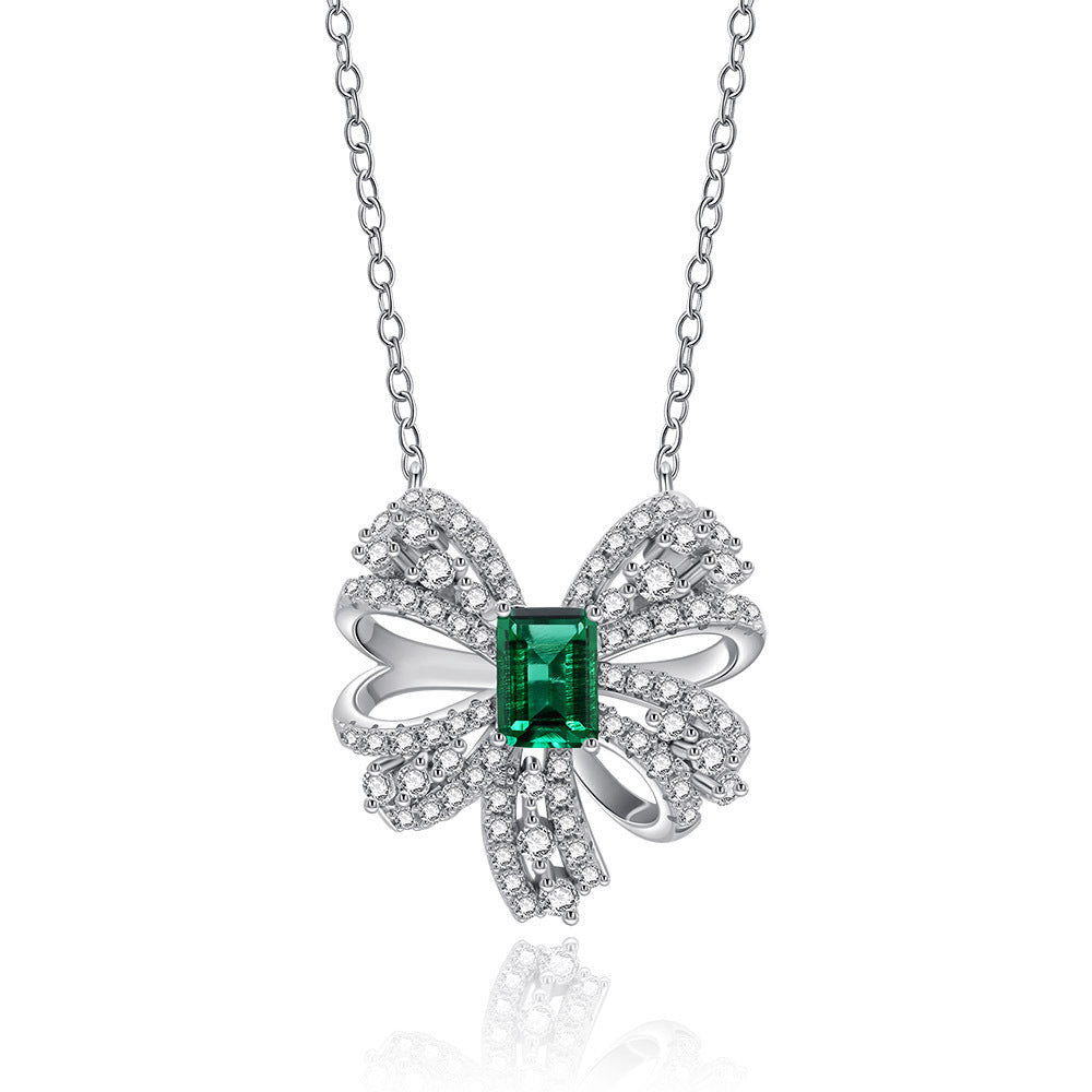 Delicate necklace featuring a created emerald set in 925 sterling silver with white gold finish, adjustable chain.