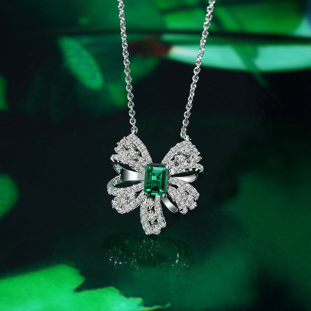 Delicate necklace featuring a created emerald set in 925 sterling silver with white gold finish, adjustable chain.
