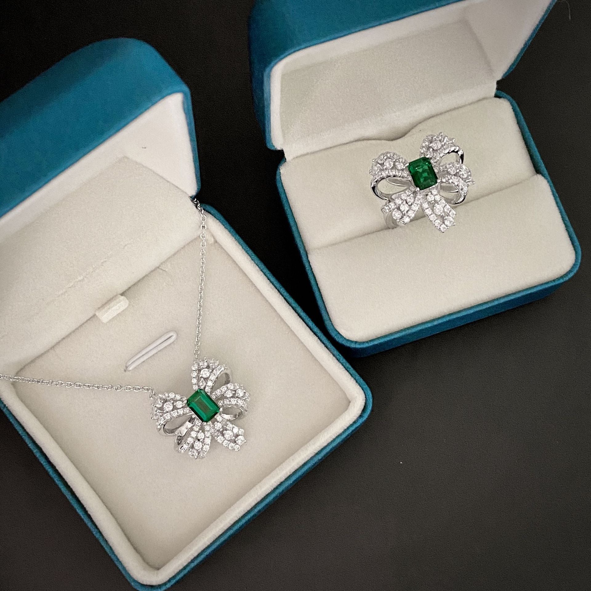 Delicate necklace featuring a created emerald set in 925 sterling silver with white gold finish, adjustable chain.