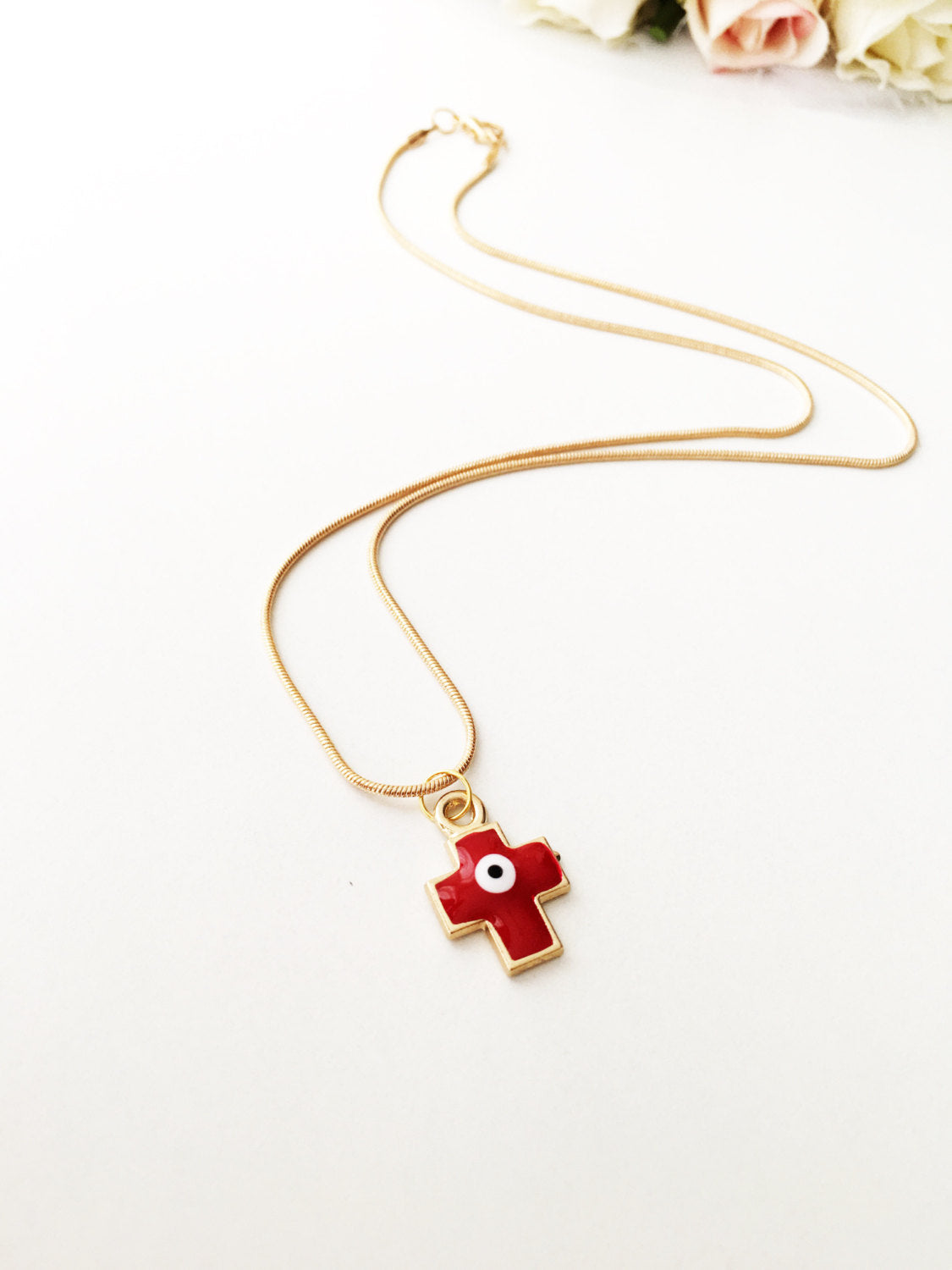 Handmade Cross Evil Eye Necklace featuring a blue and red charm on a gold plated chain.