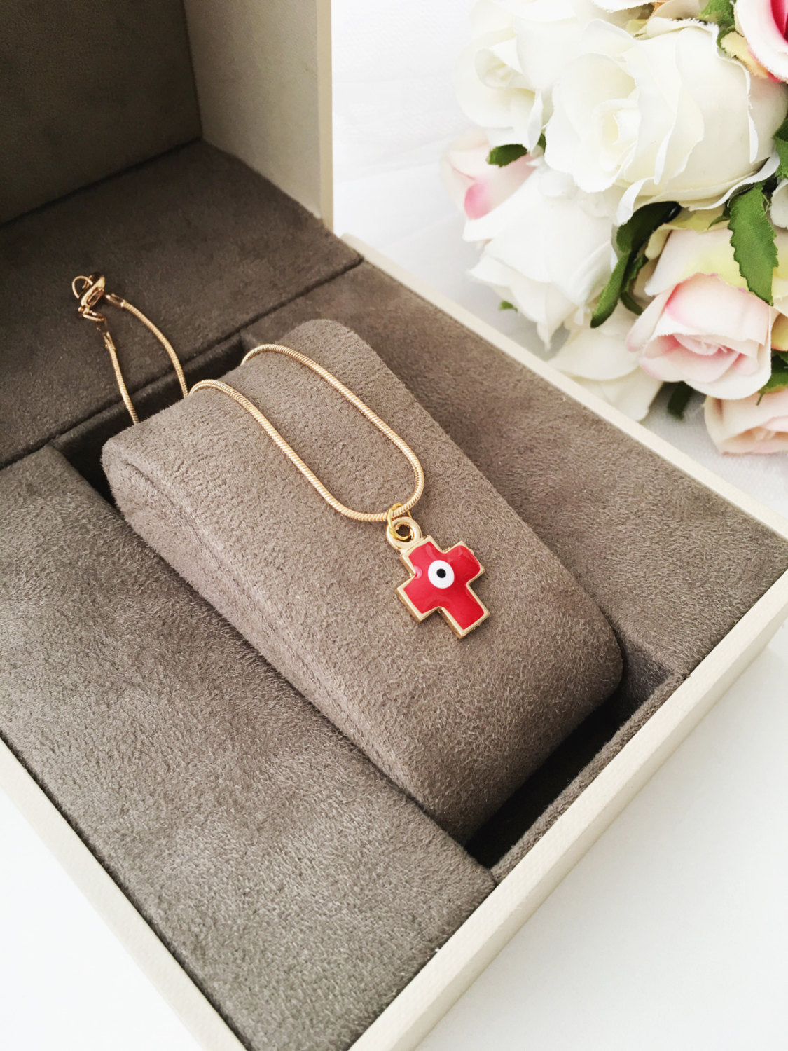 Handmade Cross Evil Eye Necklace featuring a blue and red charm on a gold plated chain.