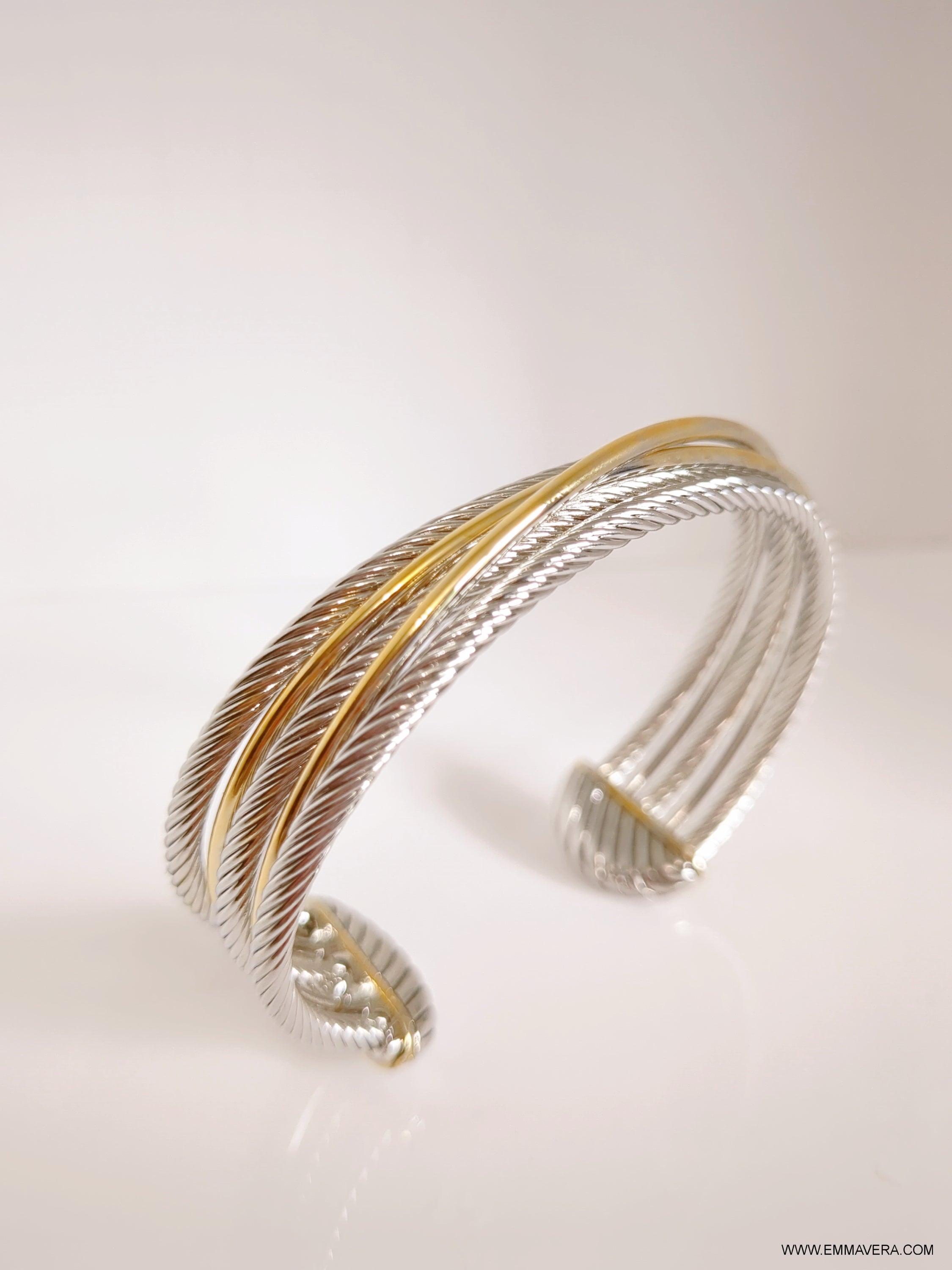 Elegant Cross Over Large Two Tone Bangle Bracelet featuring a unique cable design with gold accents, showcasing its stylish and modern appeal.