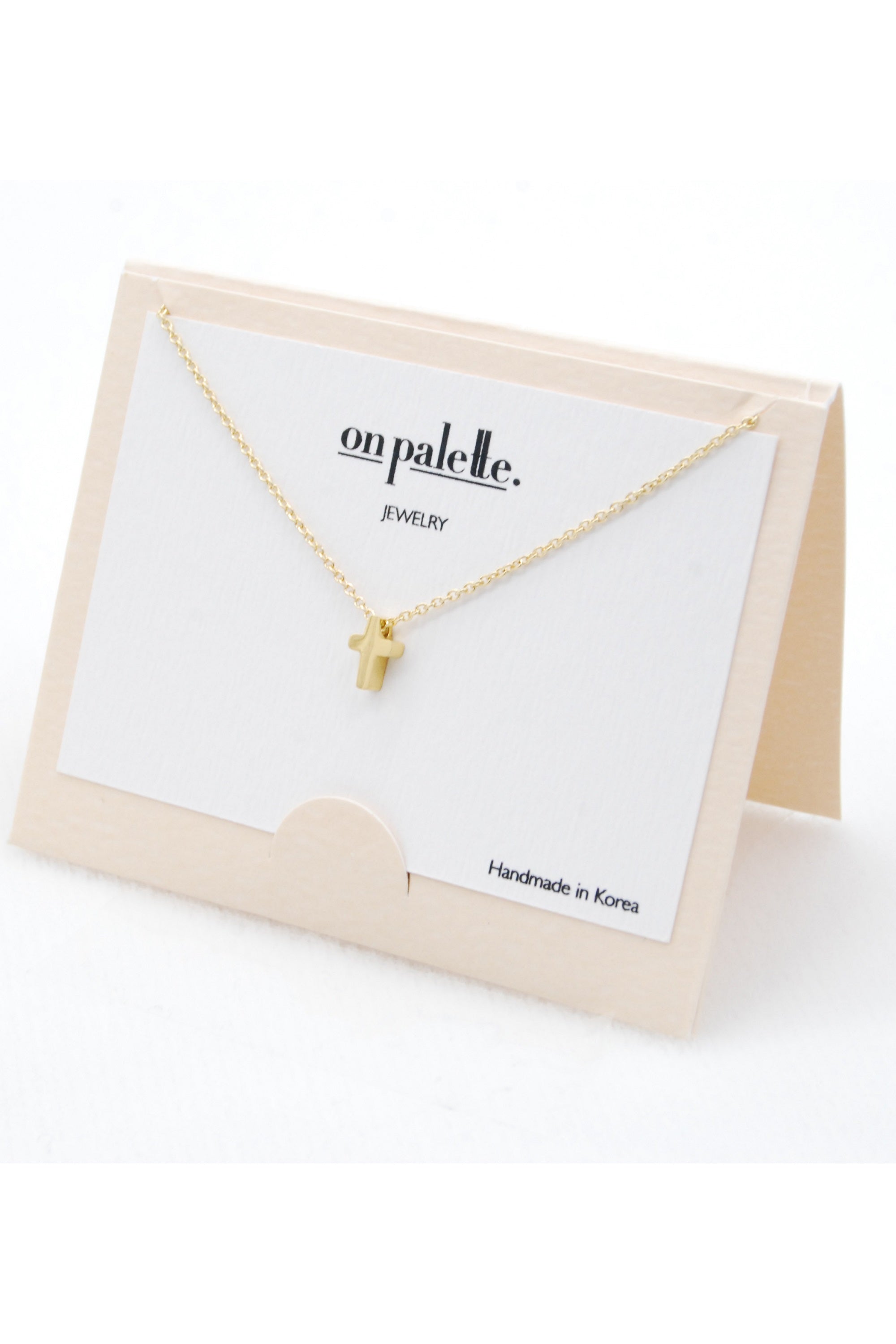 A stylish cross pendant necklace by DOBBI, made of stainless steel, showcasing its elegant design and various color options.