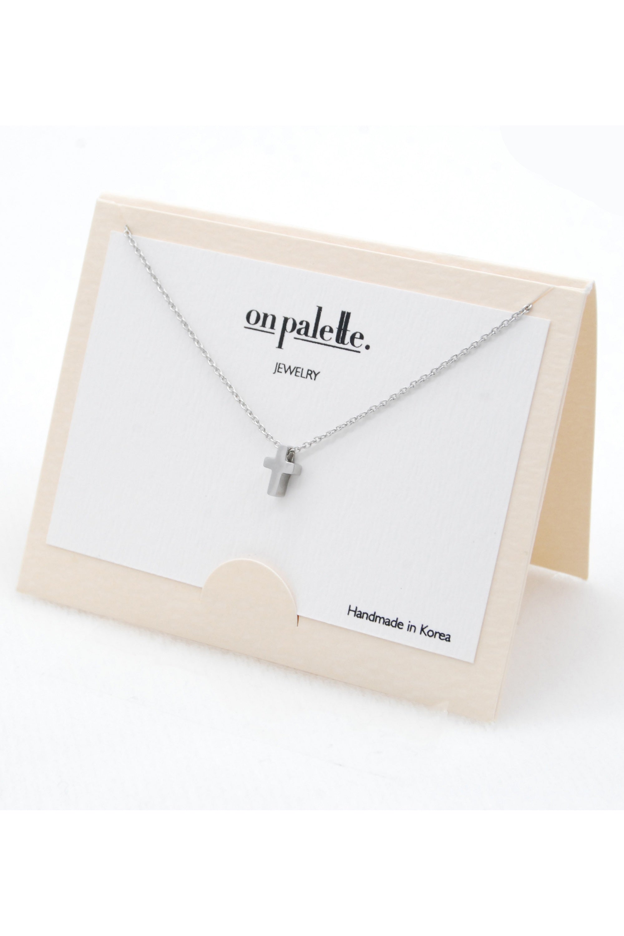 A stylish cross pendant necklace by DOBBI, made of stainless steel, showcasing its elegant design and various color options.