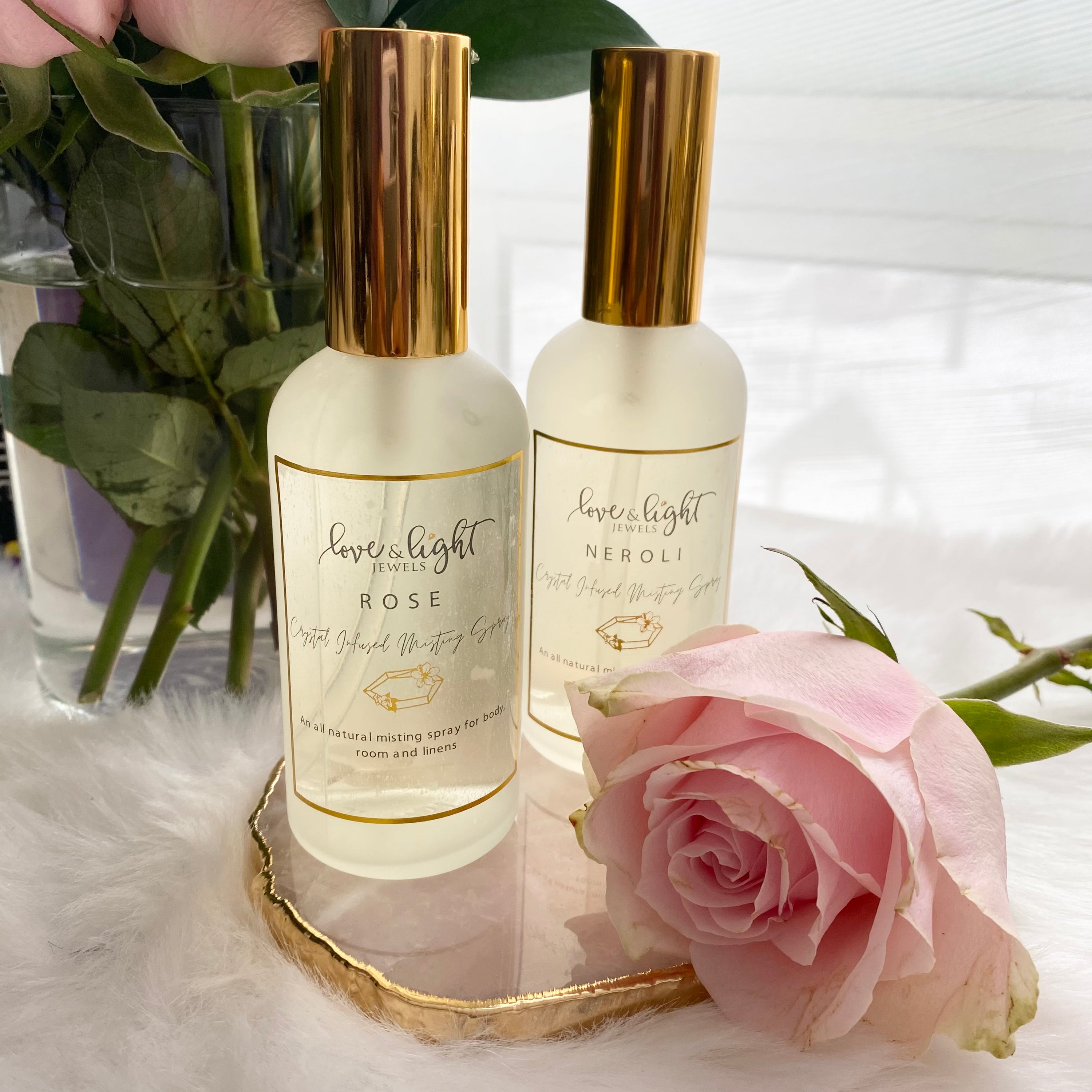 A bottle of Crystal Infused Misting Spray with gemstone chips, showcasing its elegant design and calming aura.