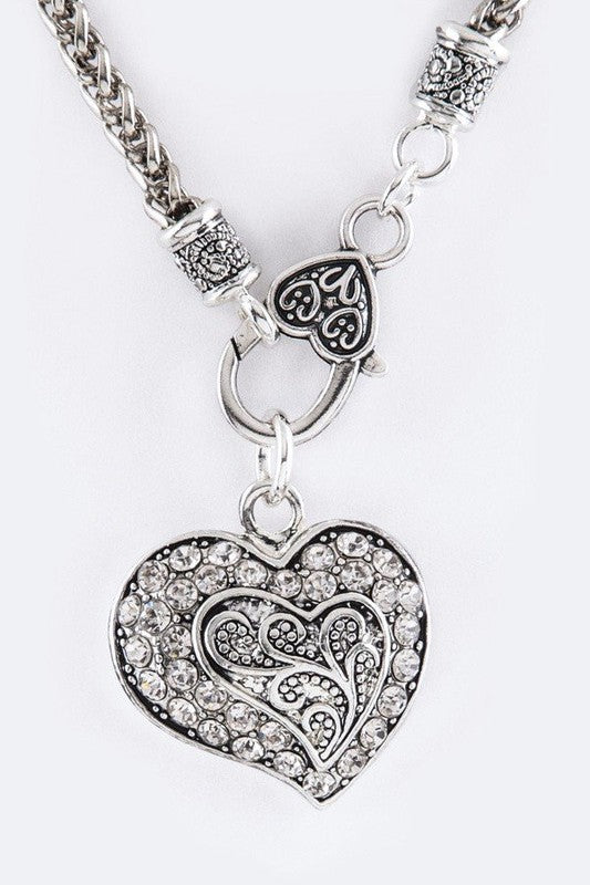Crystal Swirl Heart Pendant Necklace Set featuring a heart-shaped pendant and matching drop earrings, elegantly displayed.