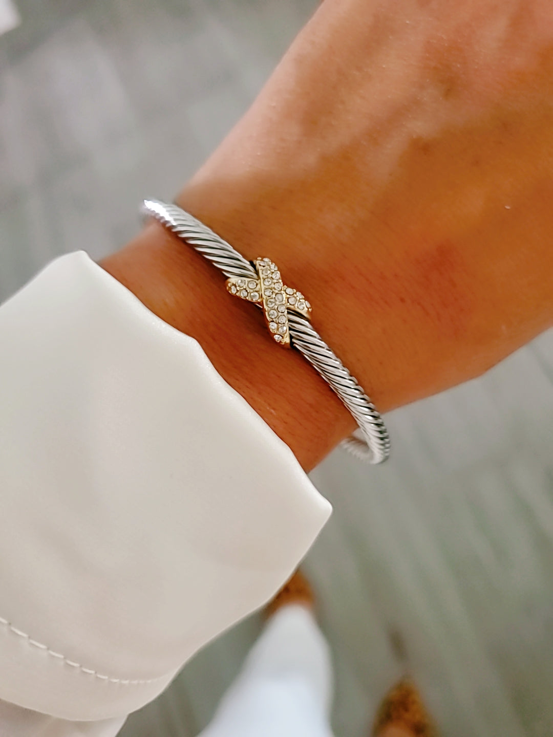 Elegant Crystals X Bangle Bracelet with 18K gold filled details and simulated diamonds, featuring a delicate cable pattern.