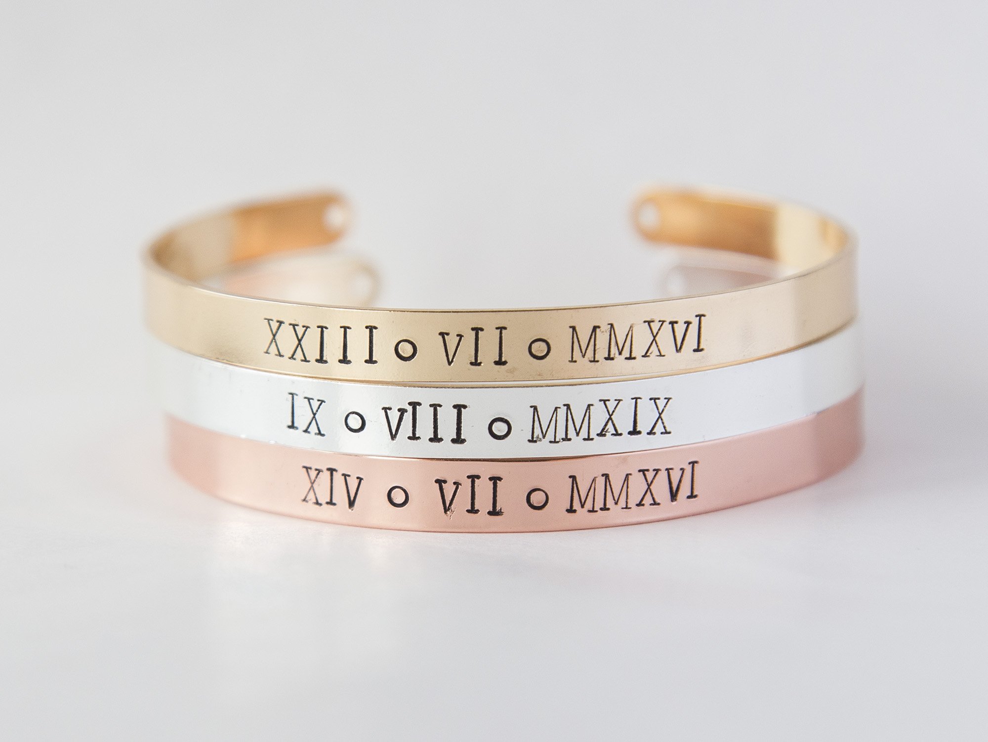Custom Roman Numerals stamped cuff bracelet in rose gold, showcasing unique hand-stamped design and adjustable size.