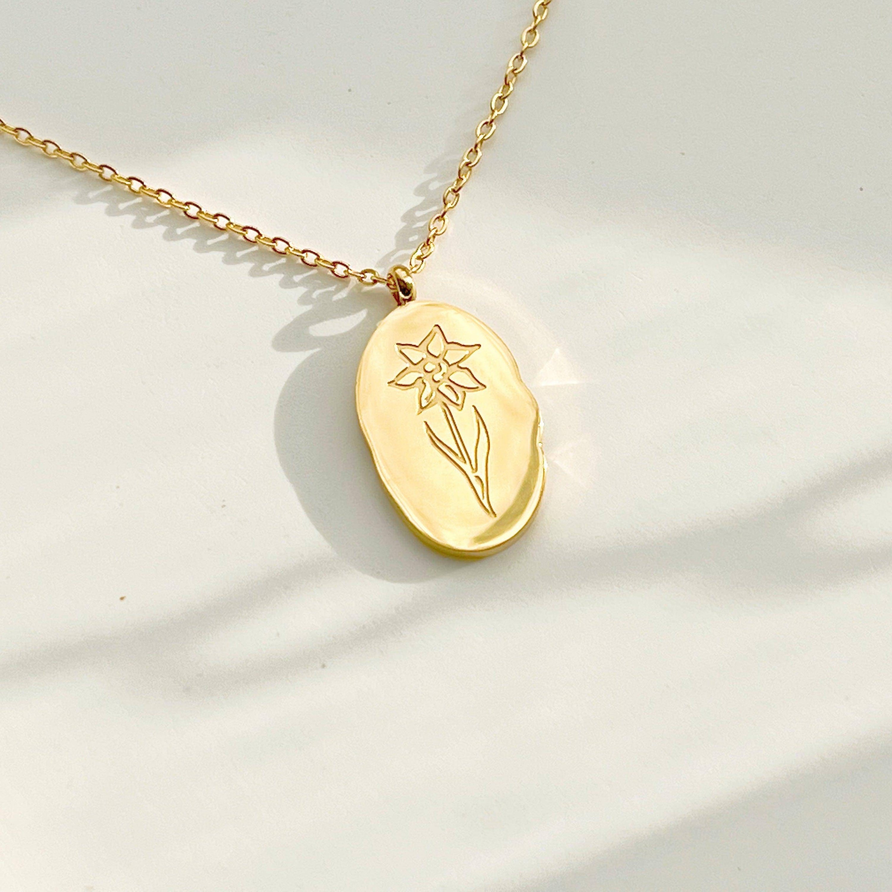 Daffodil Pendant Necklace featuring a gold plated stainless steel charm with a daffodil flower pattern, displayed elegantly on a soft background.