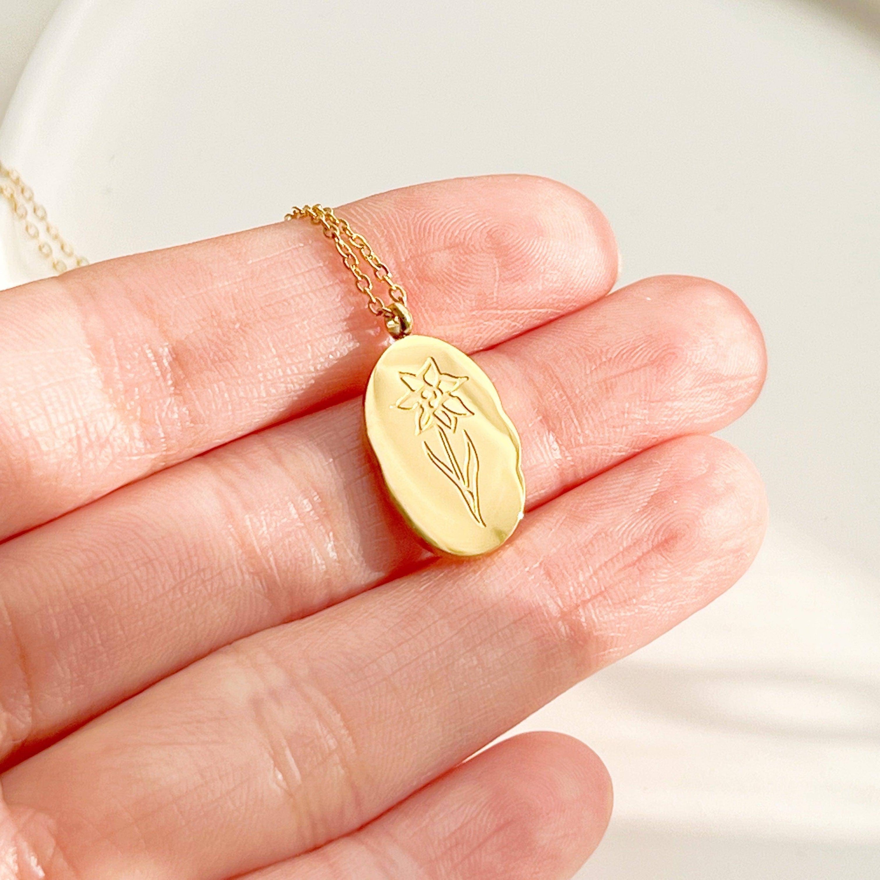 Daffodil Pendant Necklace featuring a gold plated stainless steel charm with a daffodil flower pattern, displayed elegantly on a soft background.