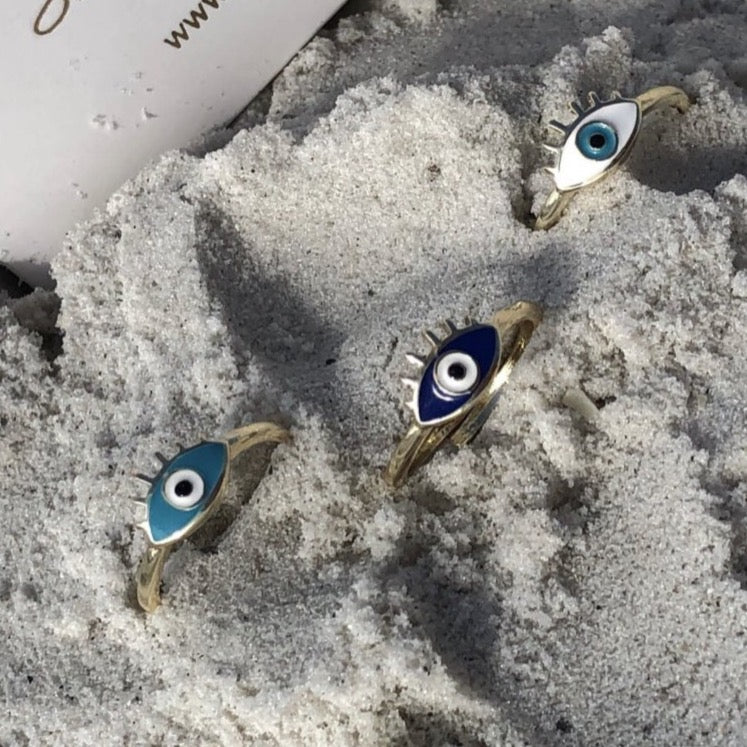 Dainty Adjustable Evil Eye Ring featuring a thin gold band and an oval evil eye in blue, turquoise, and white colors.