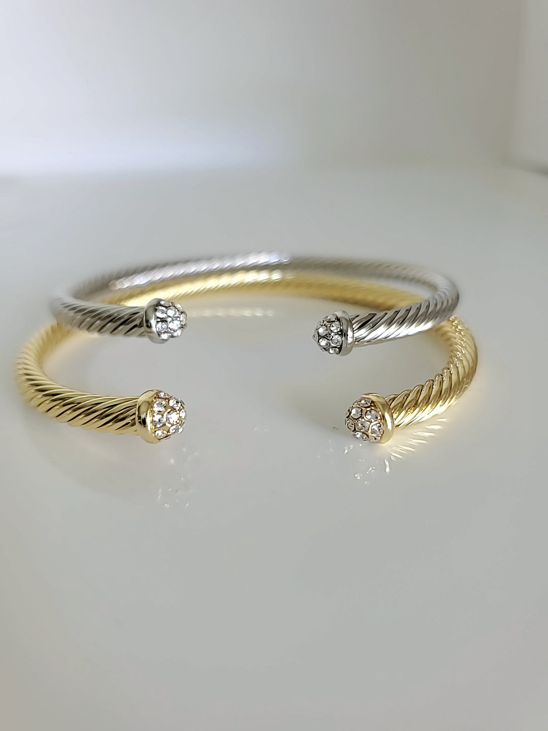 Dainty Crystals Dome Bangle in Gold and Silver with a sleek cable design and dome ends, showcasing its elegant and modern style.